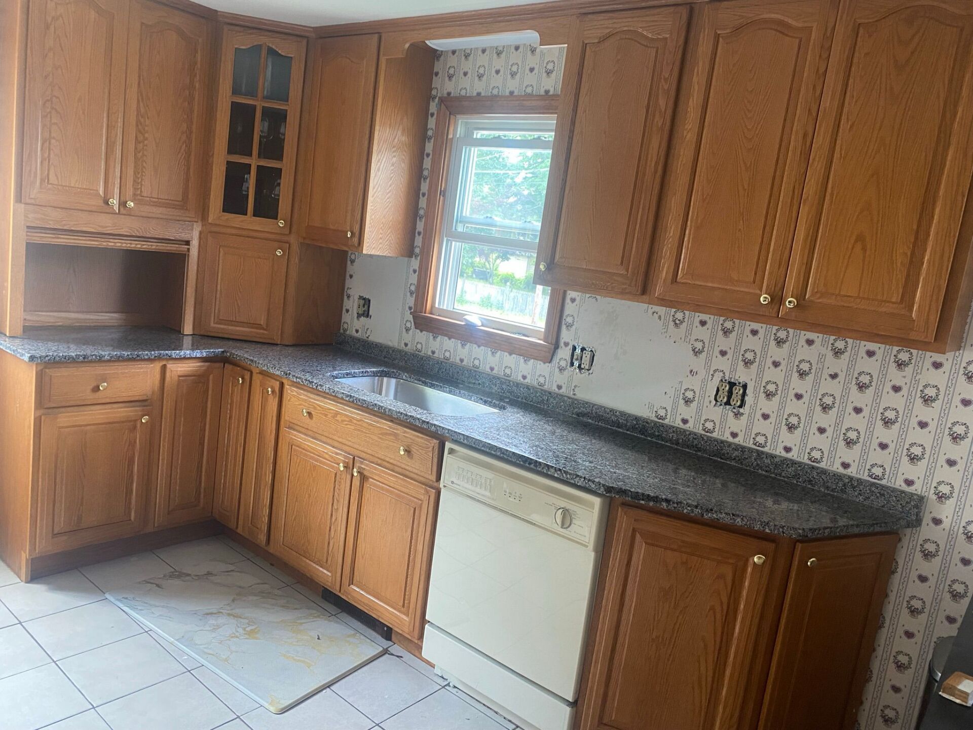 A kitchen with wooden cabinets and granite counter tops