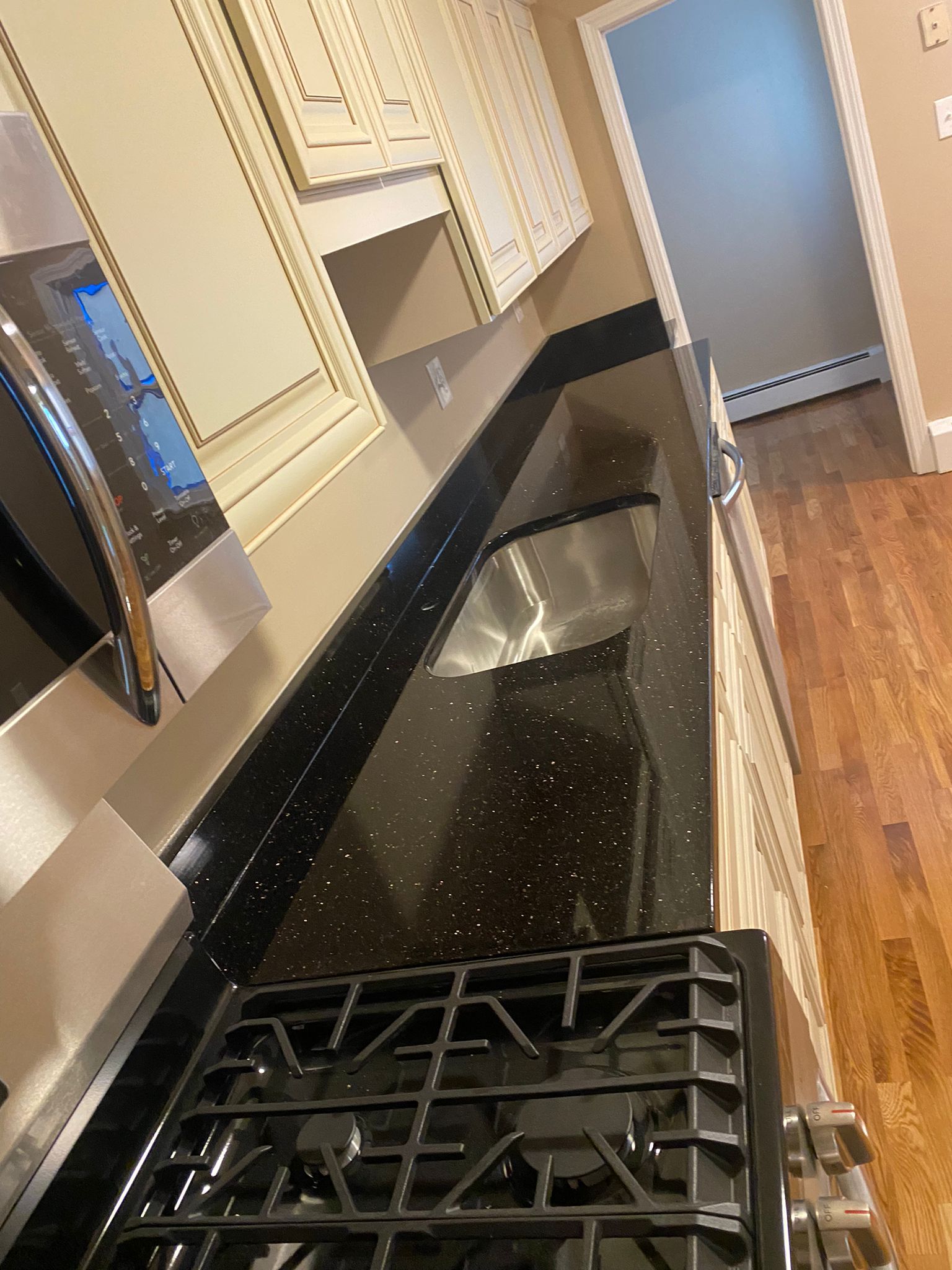 A kitchen with a stove , sink , and microwave.