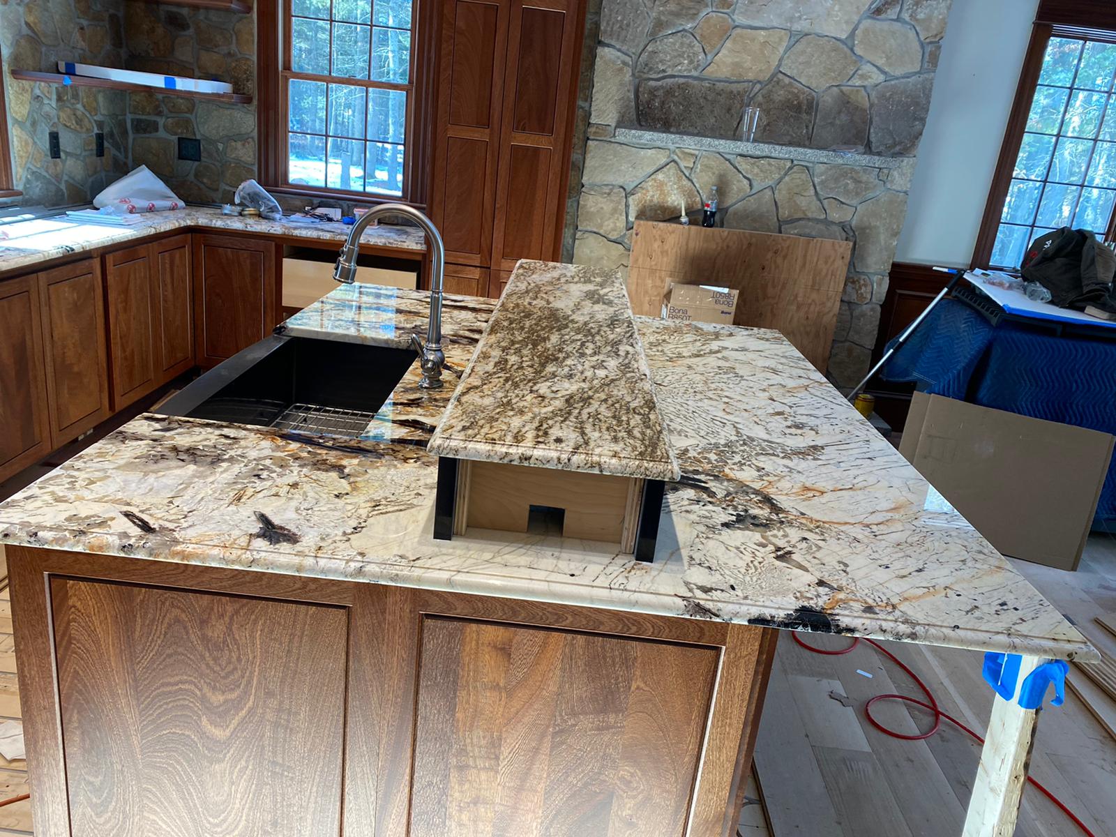 A kitchen with a granite counter top and a sink.