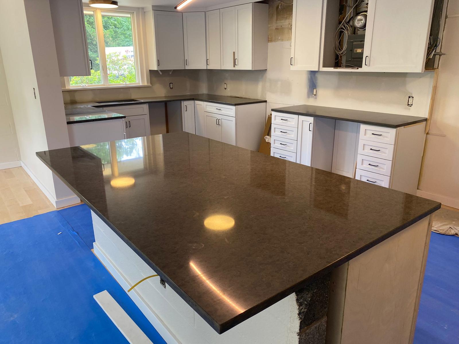 A kitchen with a large island and white cabinets
