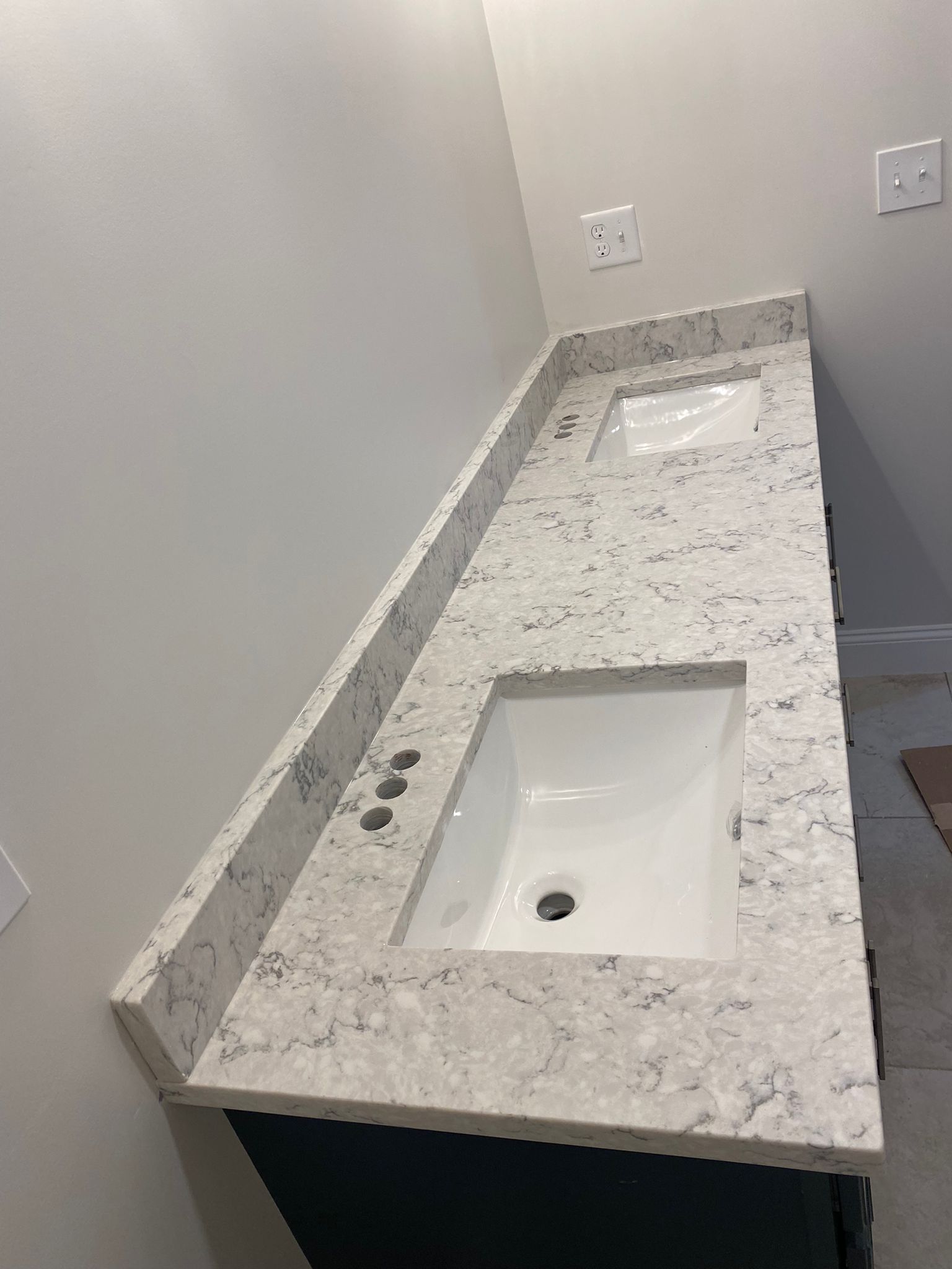 A bathroom with two sinks and a granite counter top.