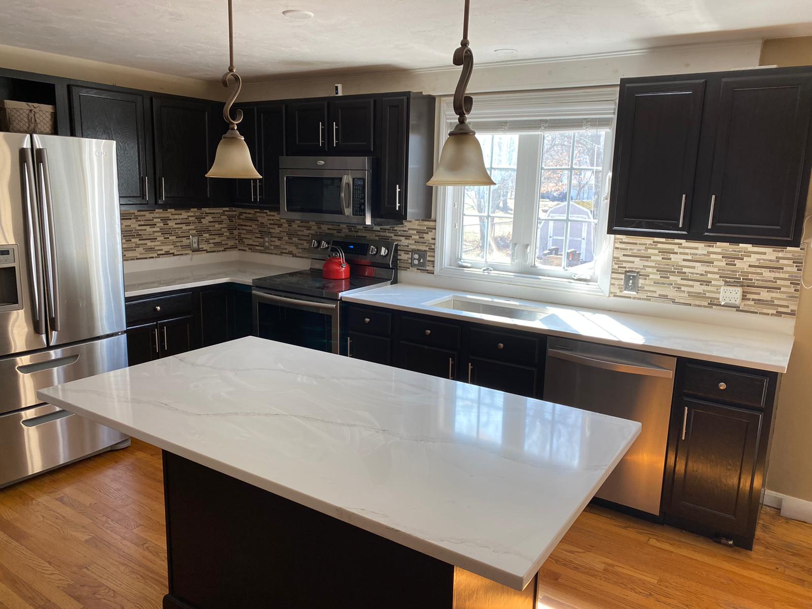 A kitchen with black cabinets and stainless steel appliances