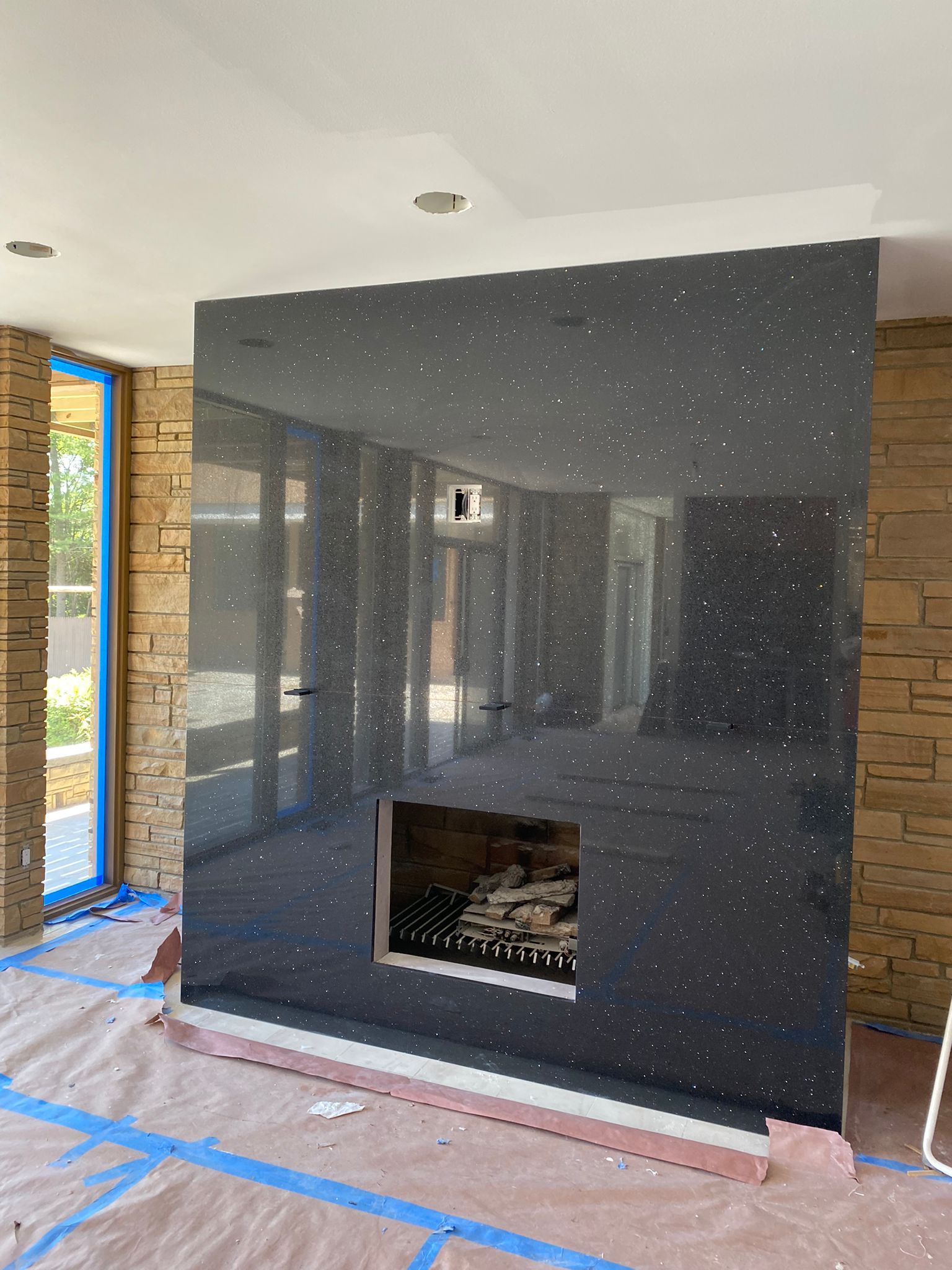 A fireplace is being built in a room with a brick wall.
