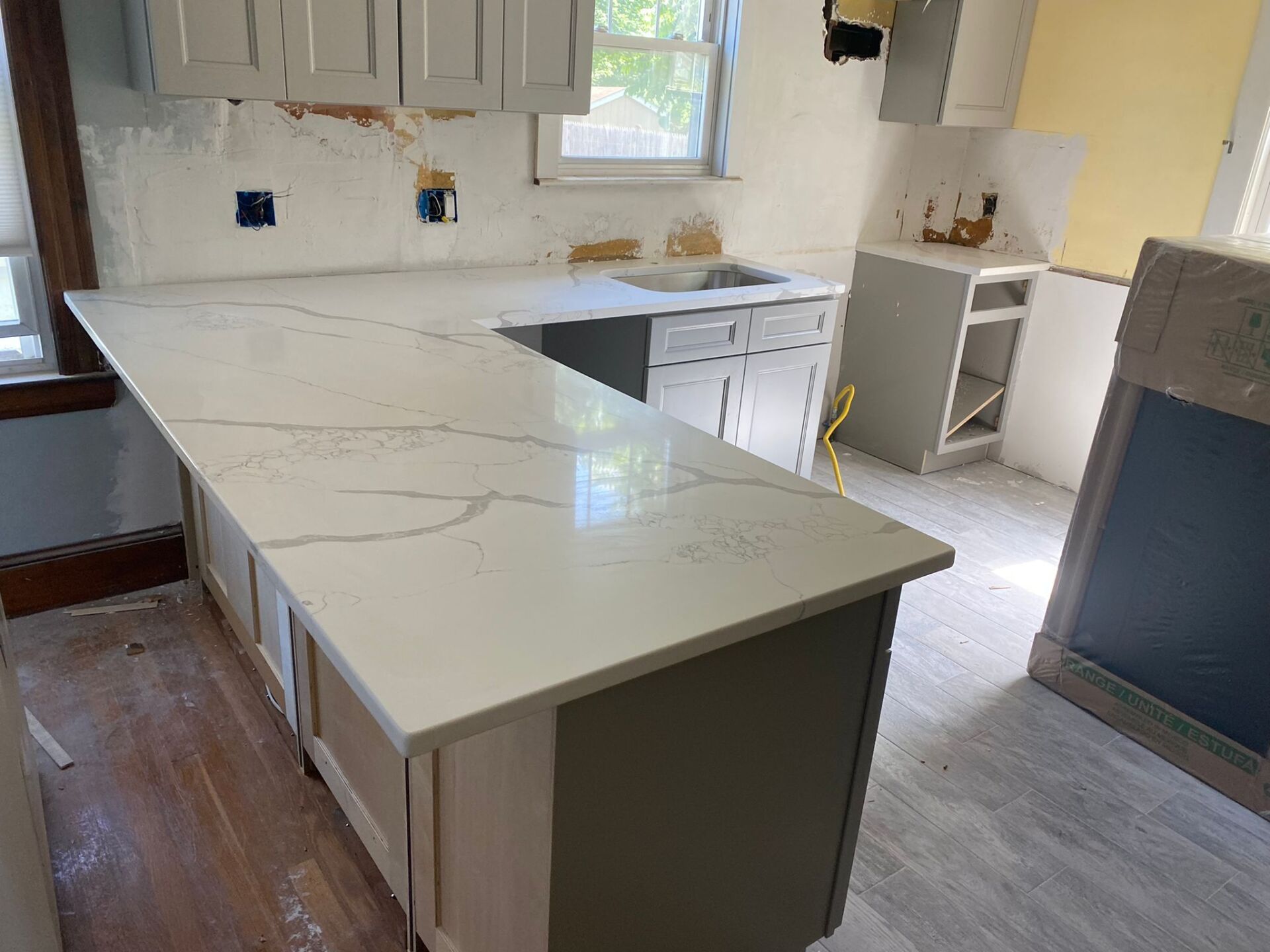 A kitchen with white cabinets and a large white counter top.