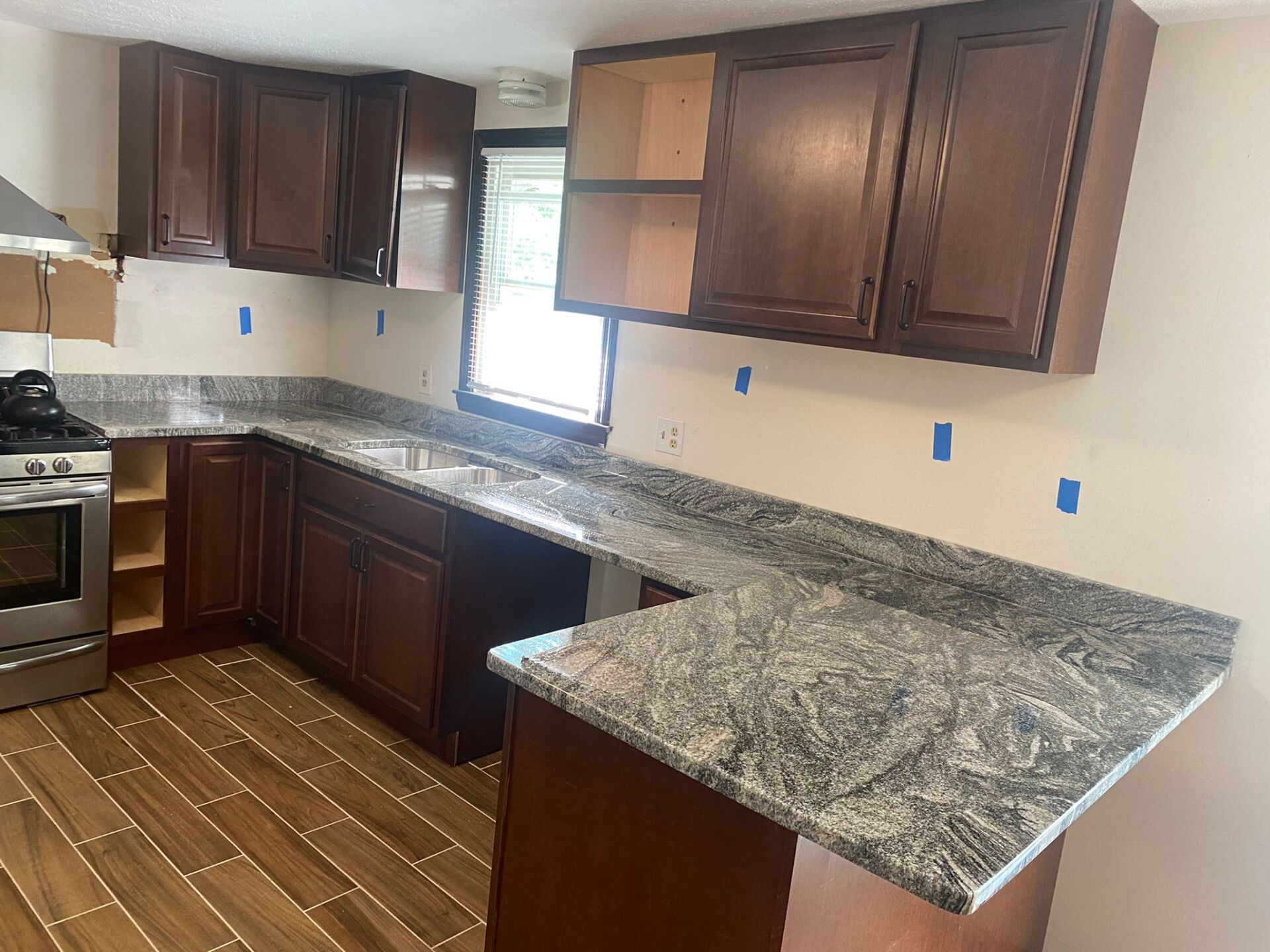 A kitchen with granite counter tops and wooden cabinets
