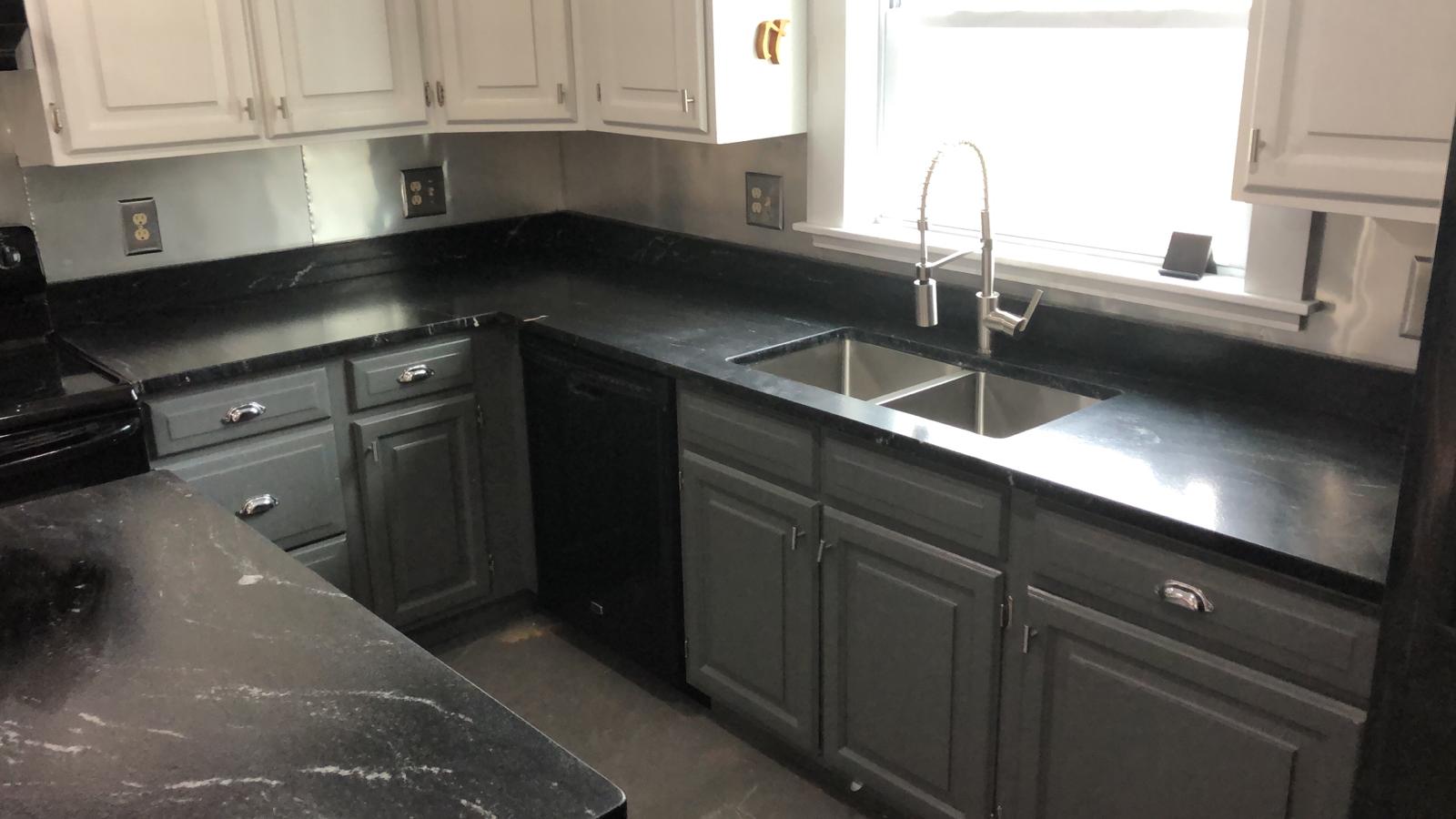 Black kitchen countertop on top of black cabinets