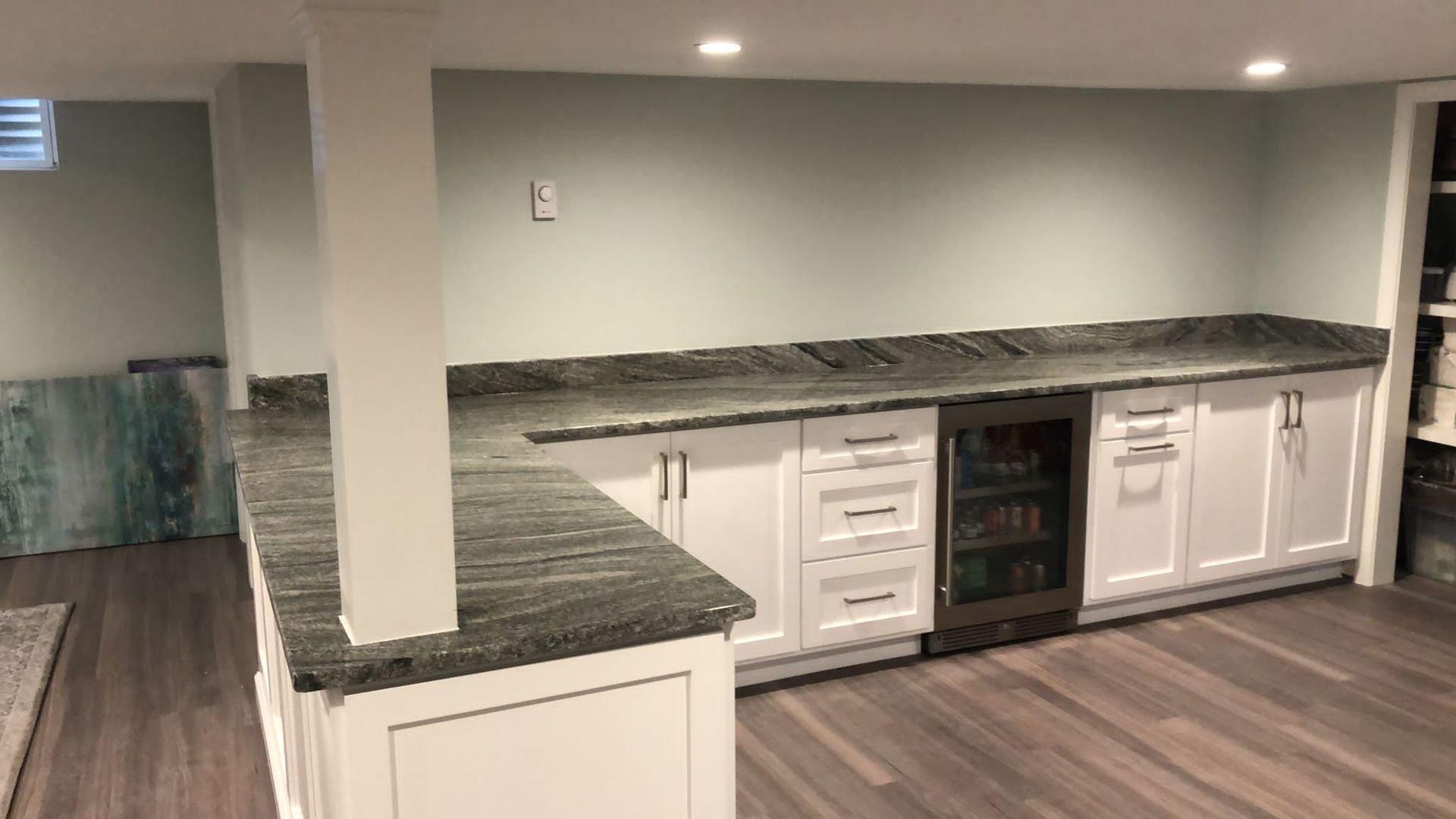 Dark kitchen granite countertop on top of white cabinets