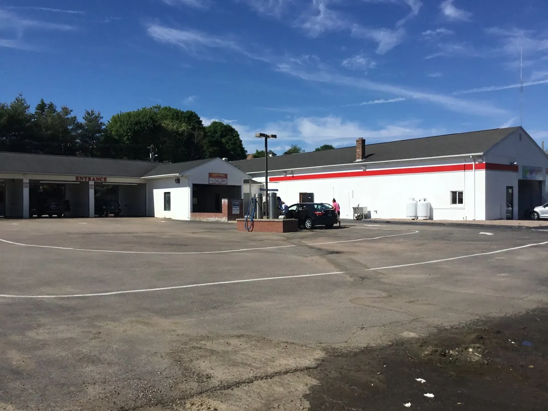 A car is parked in front of a large white building