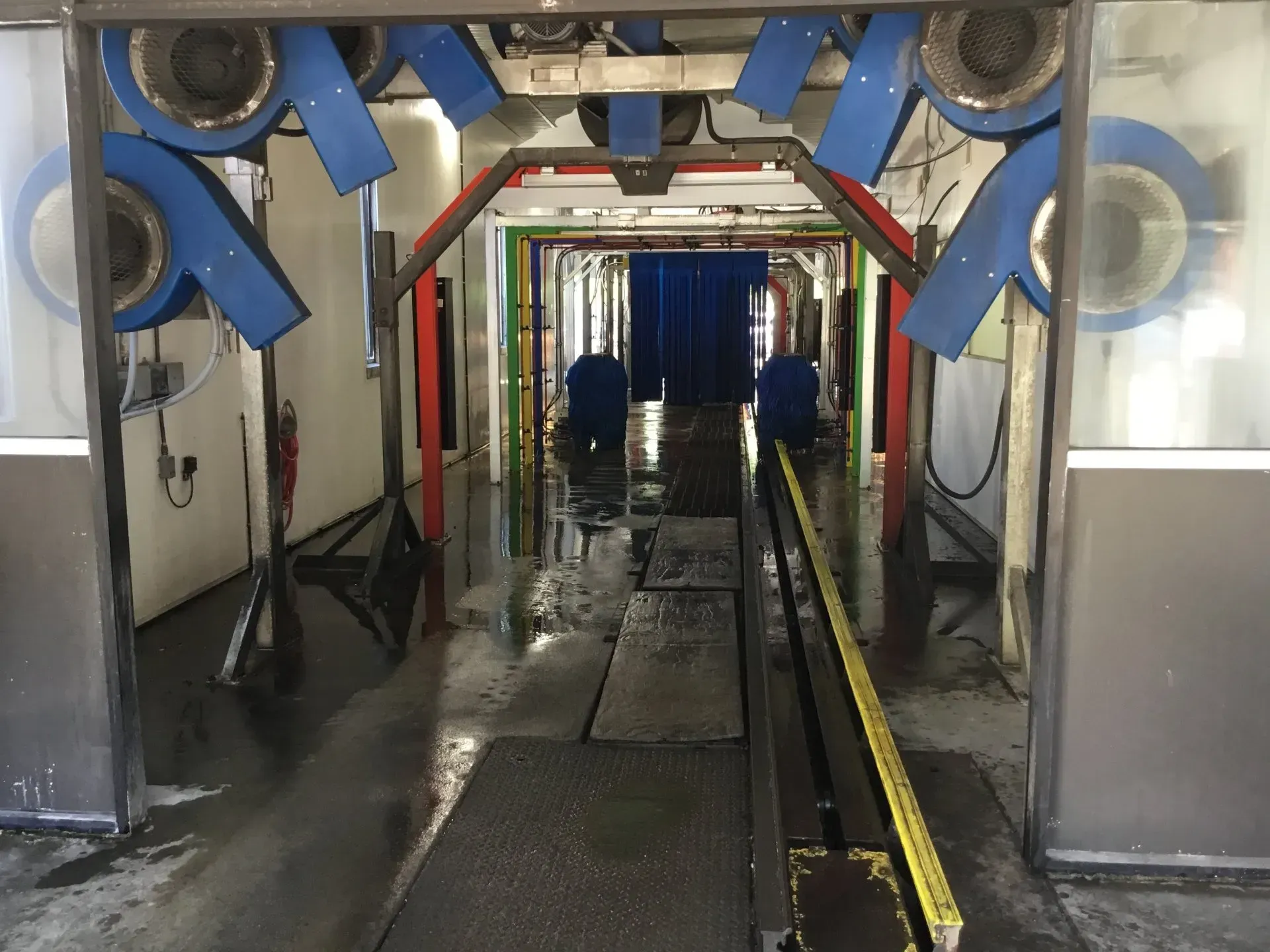 A car wash with a blue curtain and a yellow line