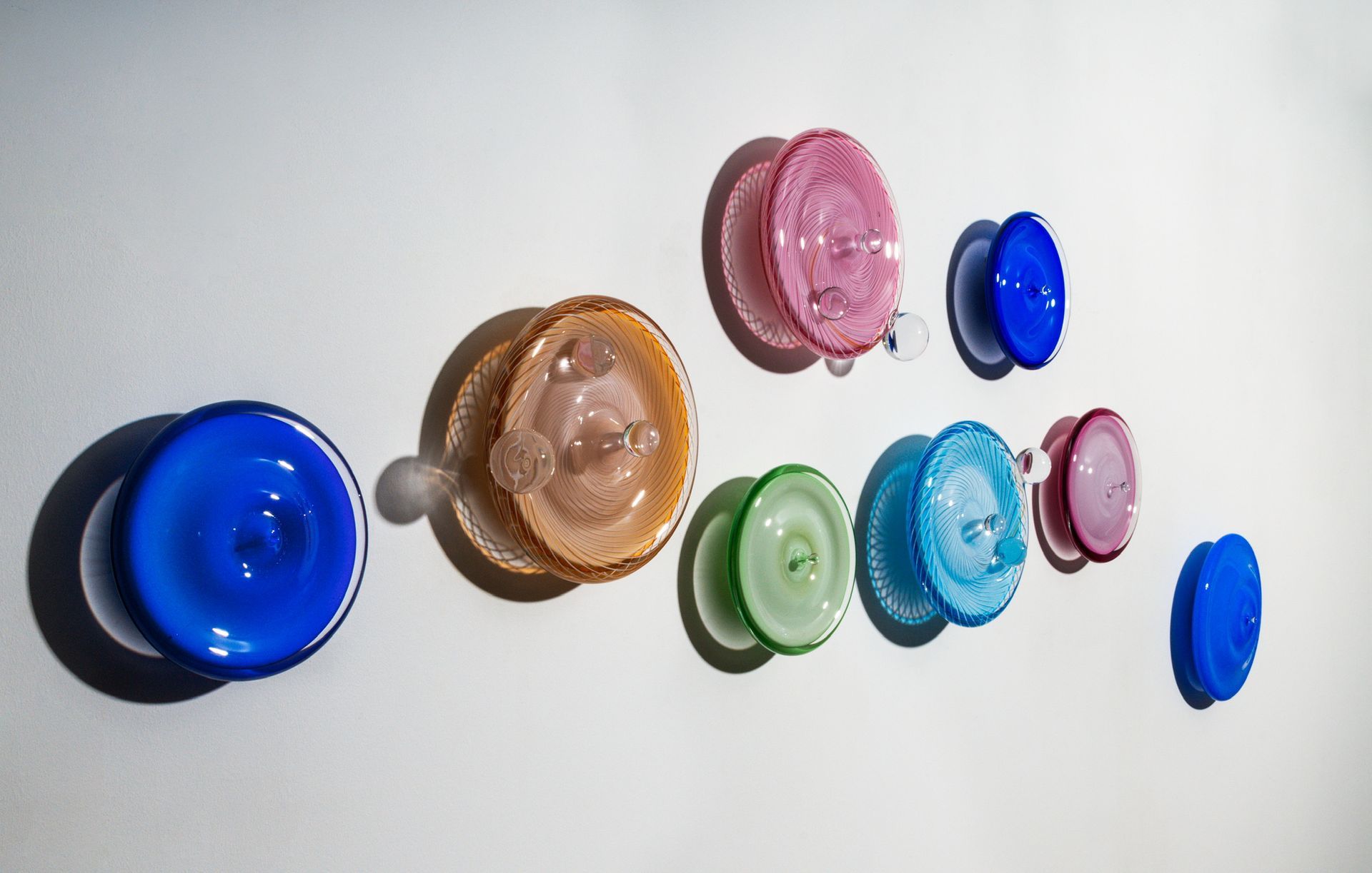 Assorted colorful round glass objects arranged on a white surface