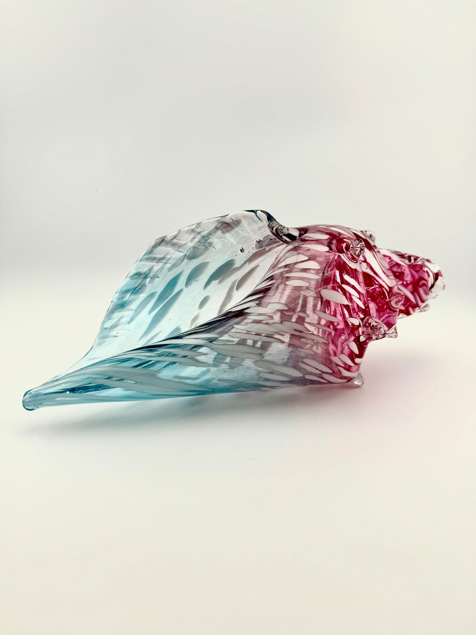 Abstract crumpled foil sculpture in blue and red on a white background