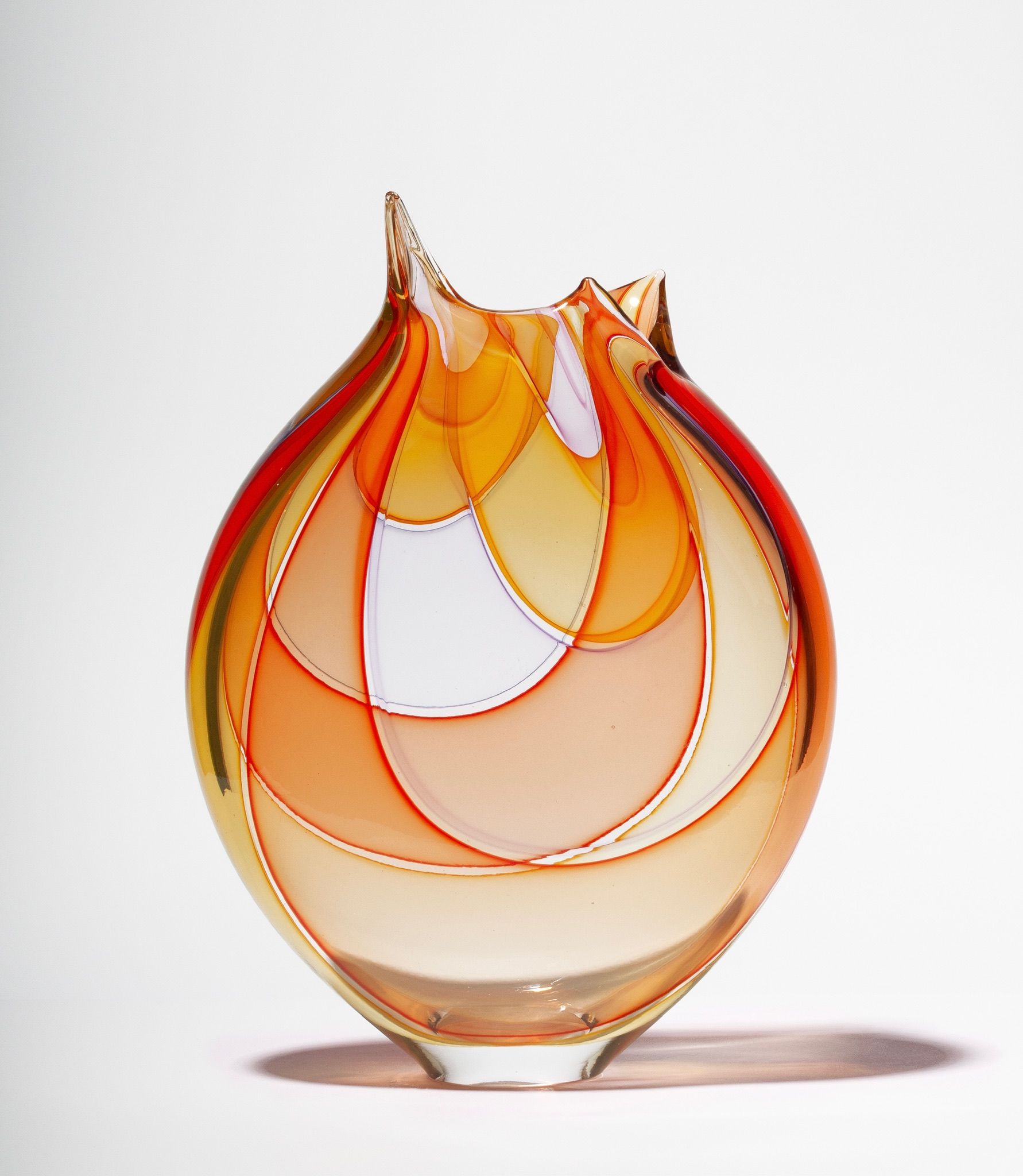 Abstract amber and red glass vase with layered petal-like curves and a flared opening
