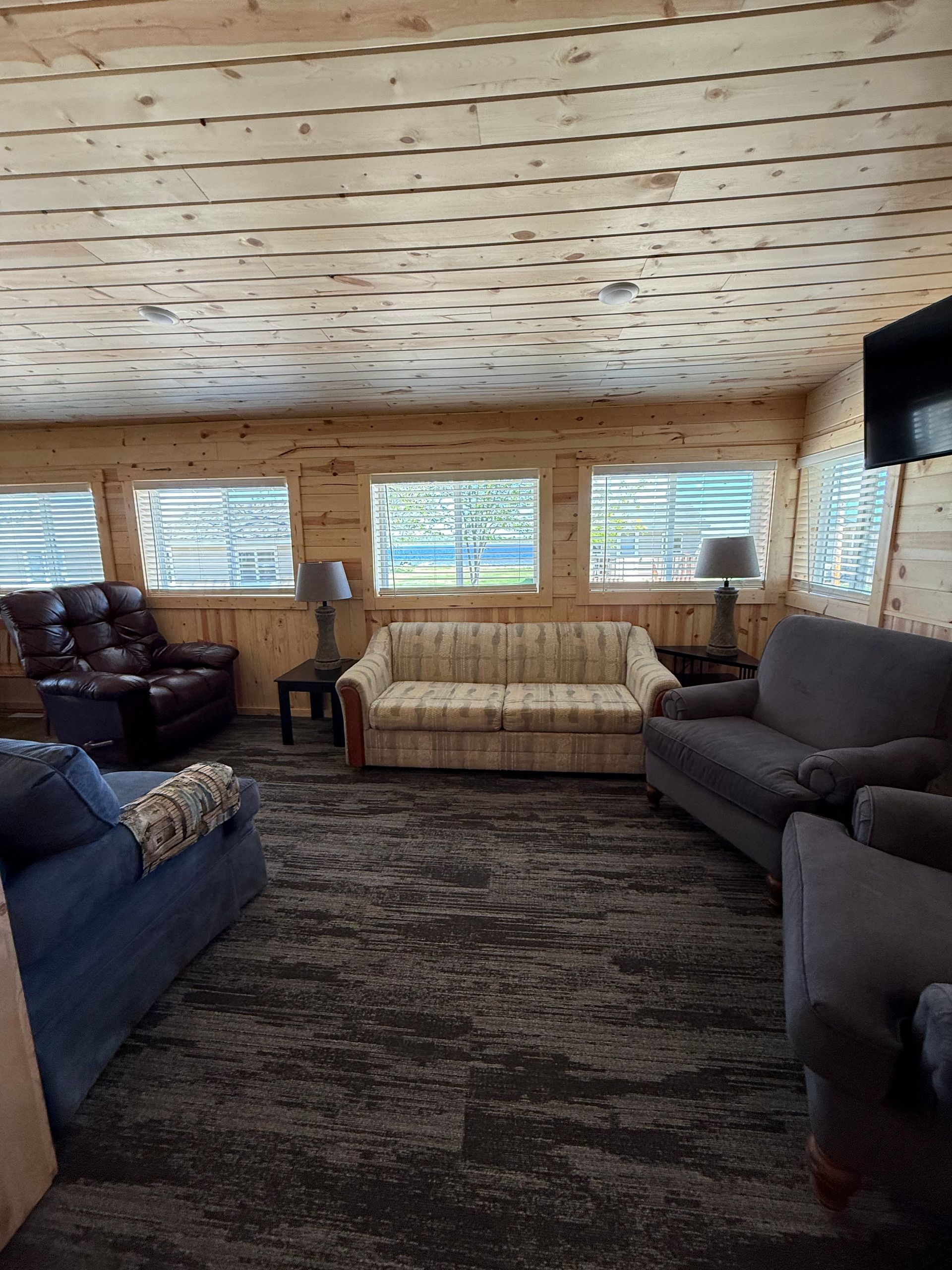 A living room with a couch , chairs and lamps