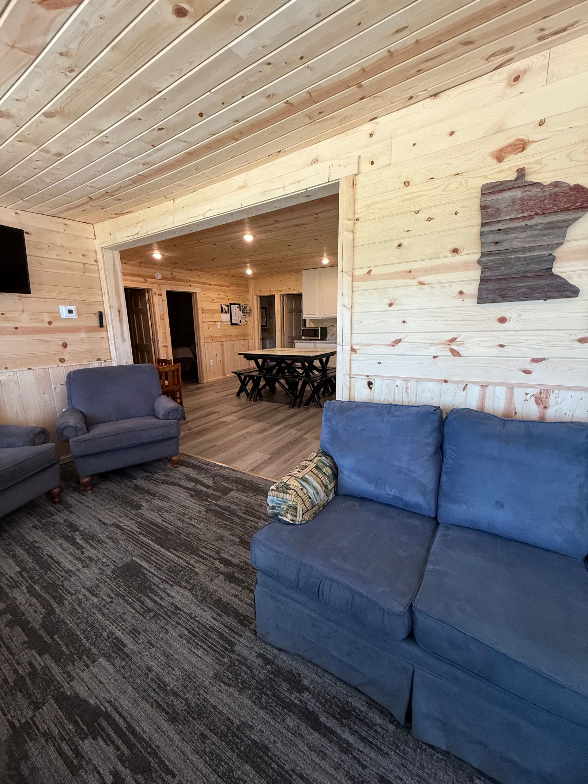 A living room with a blue couch , two chairs , and a table.