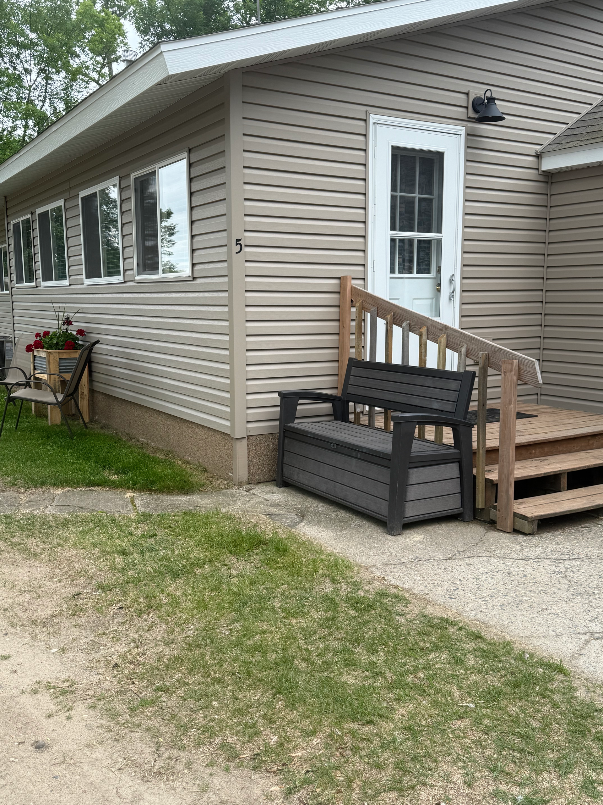 A house with a bench and stairs in front of it.