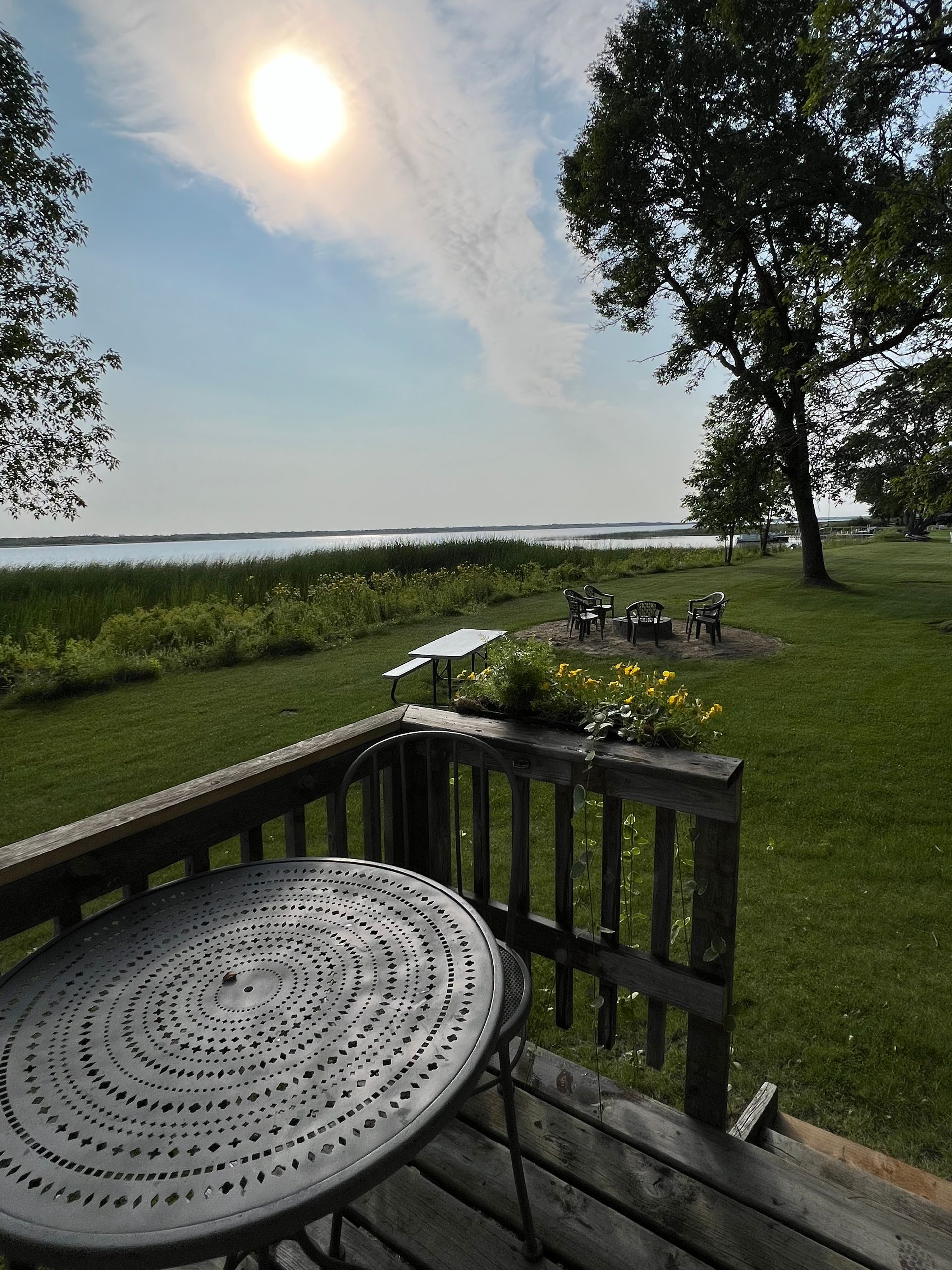 A table and chairs on a deck overlooking a lake