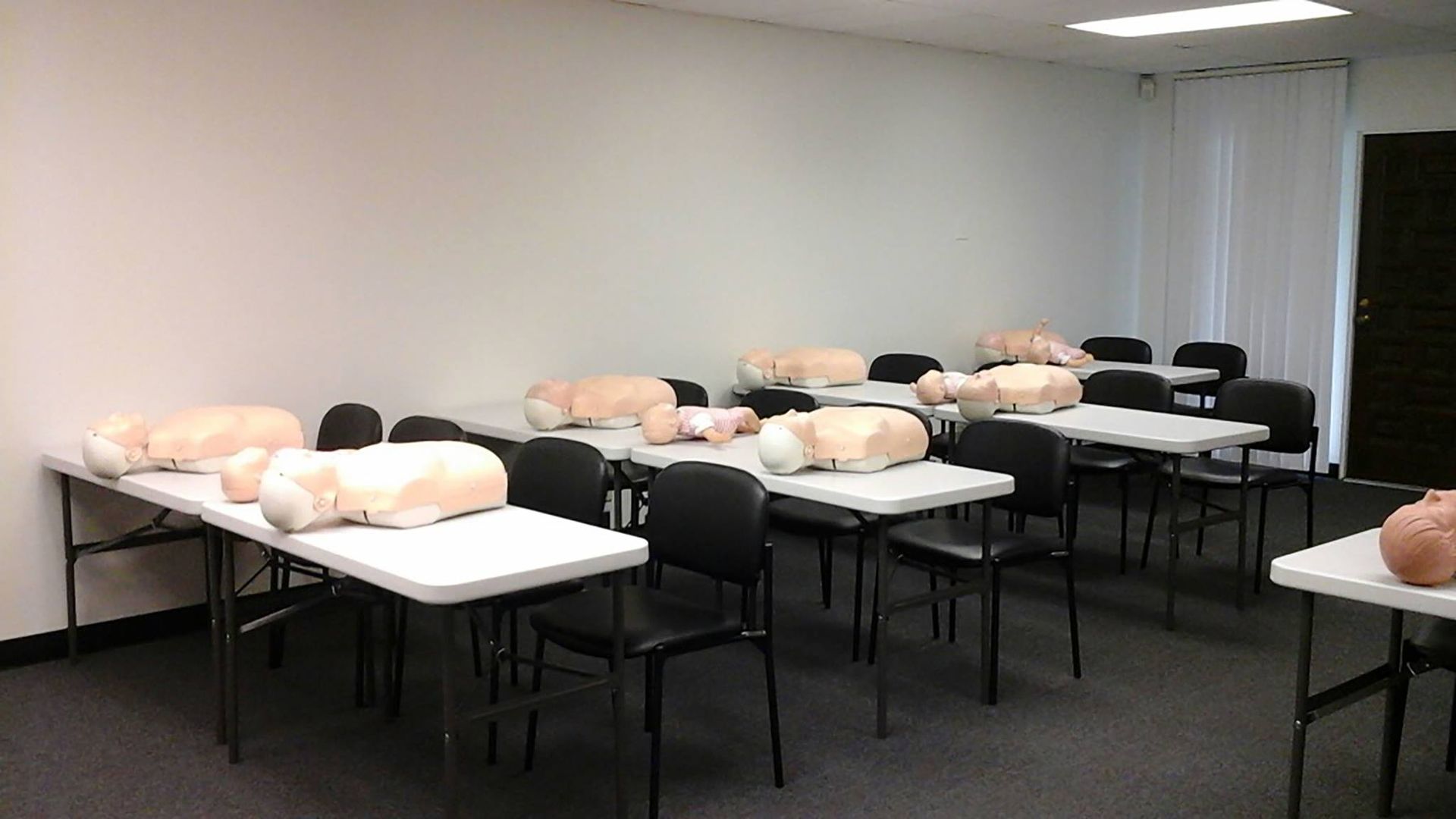 A room filled with tables and chairs with mannequins on them