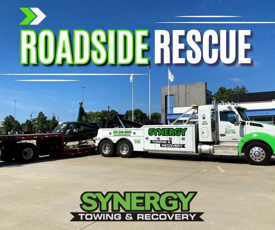 Roadside rescue: tow truck with Synergy logo towing a car on a sunny day. Green, white, and black colors.