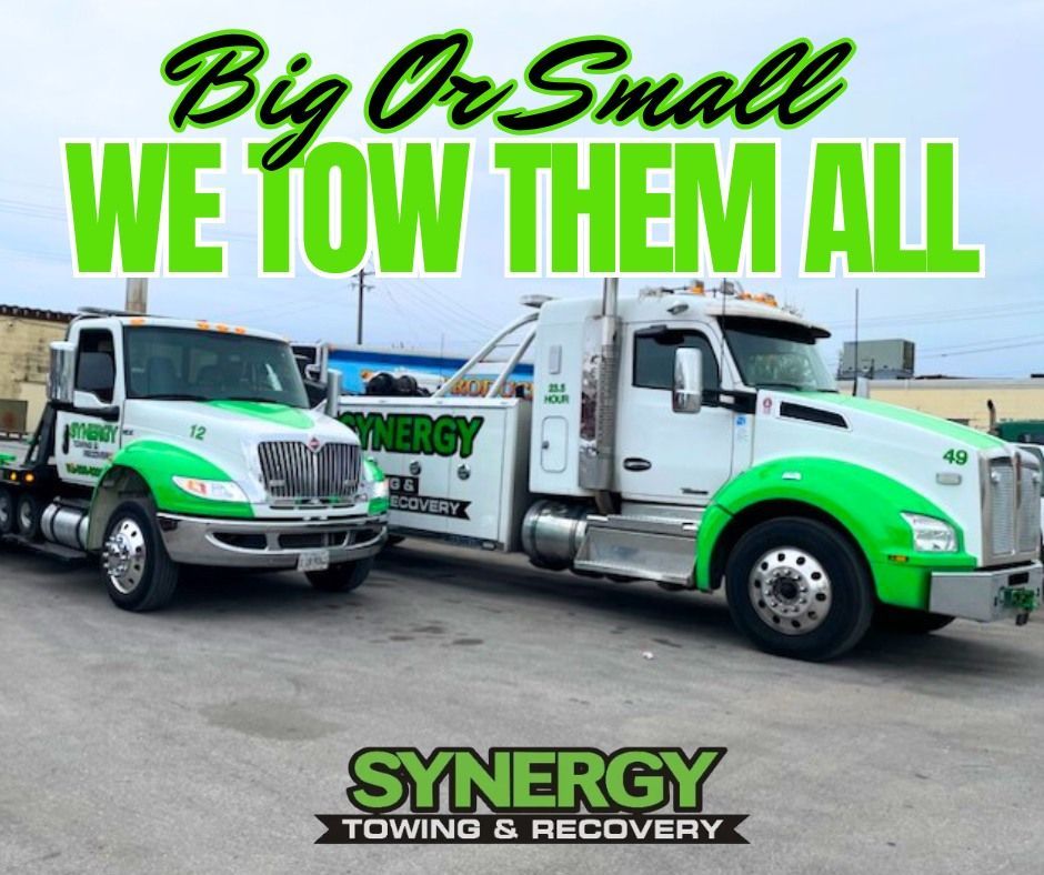 Two Synergy Towing trucks, white with green accents, side-by-side. Text: 