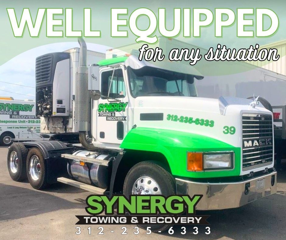White and green semi-truck for Synergy Towing & Recovery, phone number visible.
