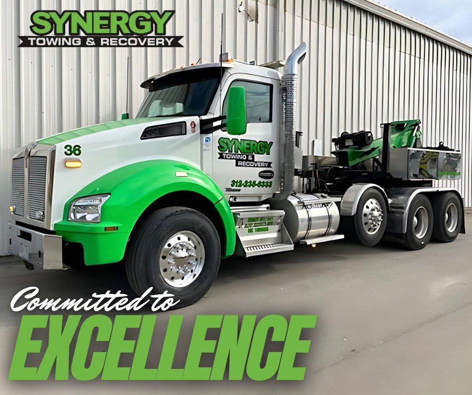 Synergy Towing & Recovery truck with green and white design, advertising 