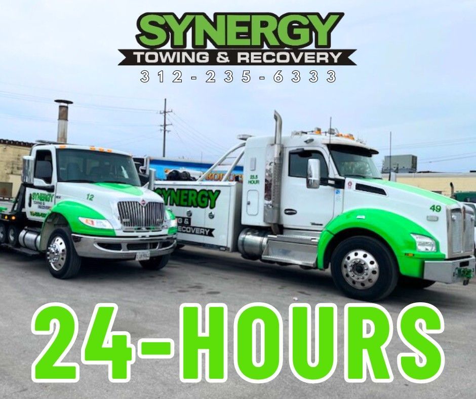 Two white and green tow trucks with 