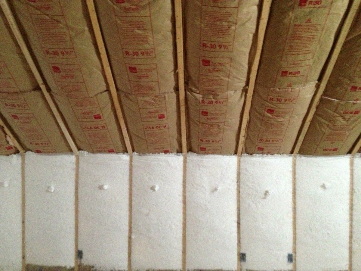 Insulated attic ceiling with exposed rafters above white wall panels