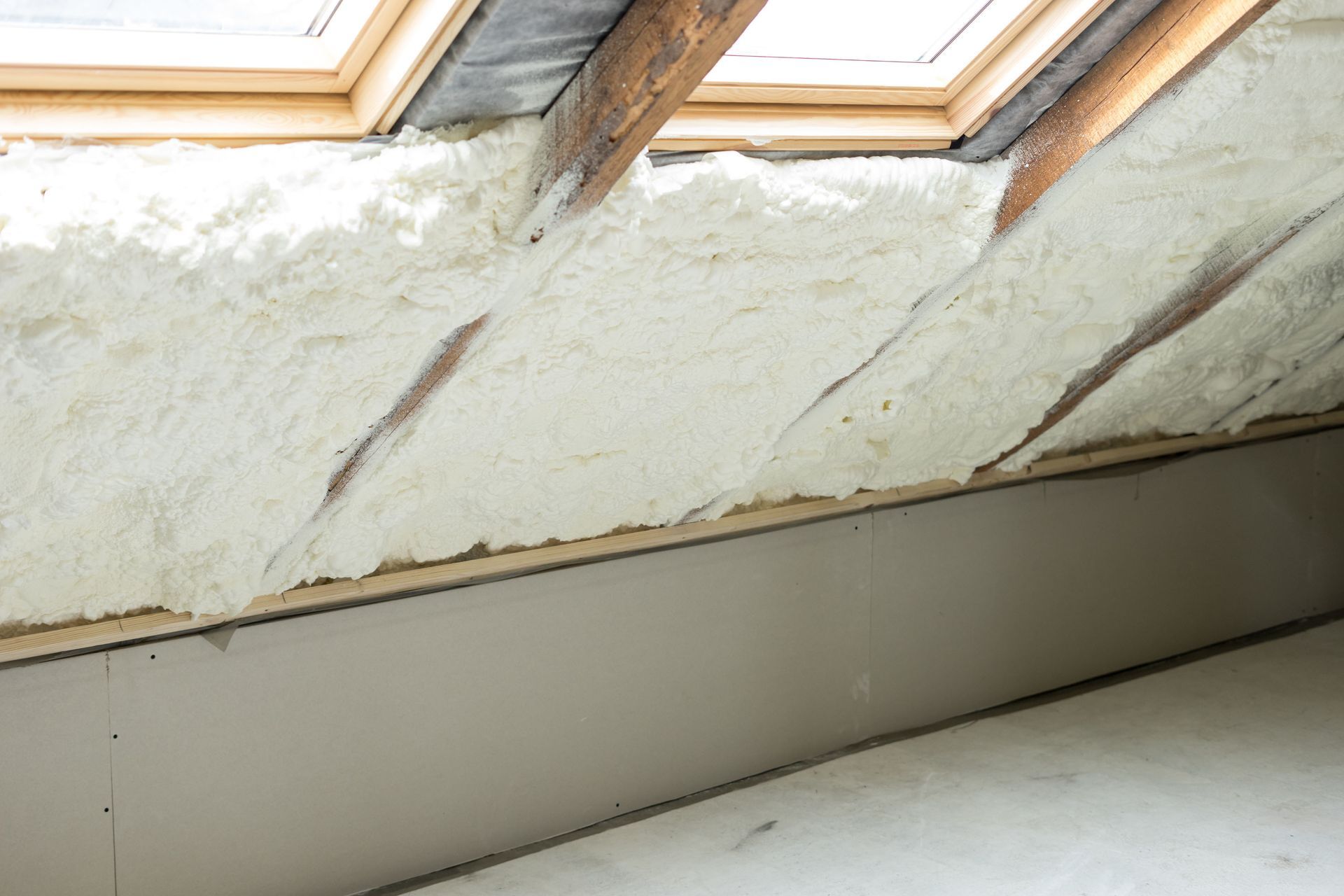 Attic ceiling with skylights and exposed insulation along a sloped wall