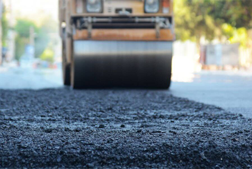A roller is rolling asphalt on a road
