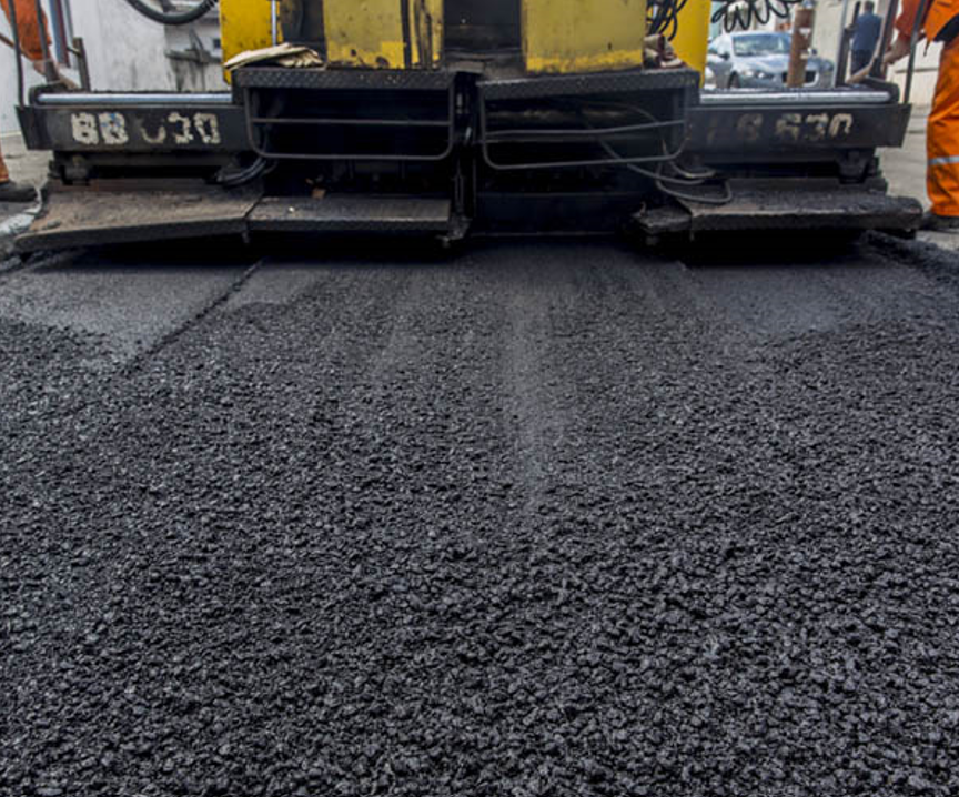 A machine is laying asphalt on a road.