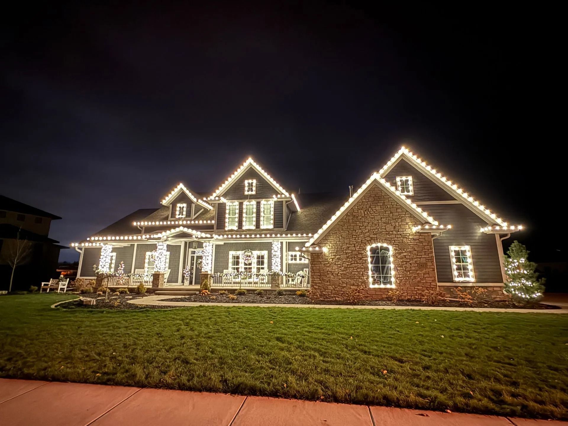 House decorated with white Christmas lights against a dark night sky.