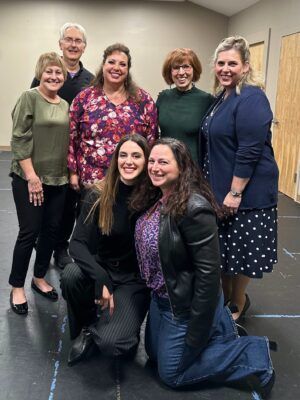 A group of women are posing for a picture together in a room.