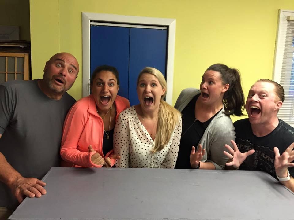 A group of people are standing around a table with their mouths open.