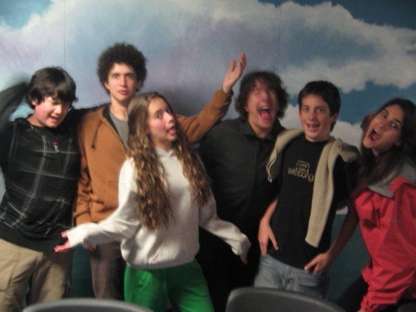 A group of young people are posing for a picture and one of them is wearing a shirt that says the north face