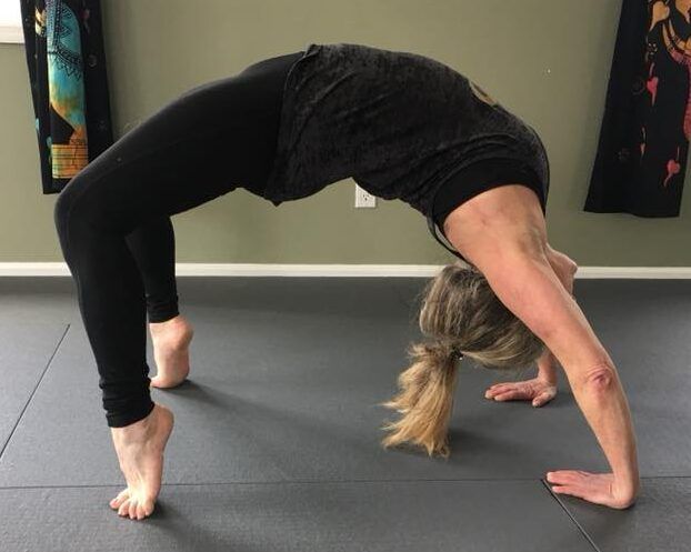 A woman is doing a yoga pose on a mat.