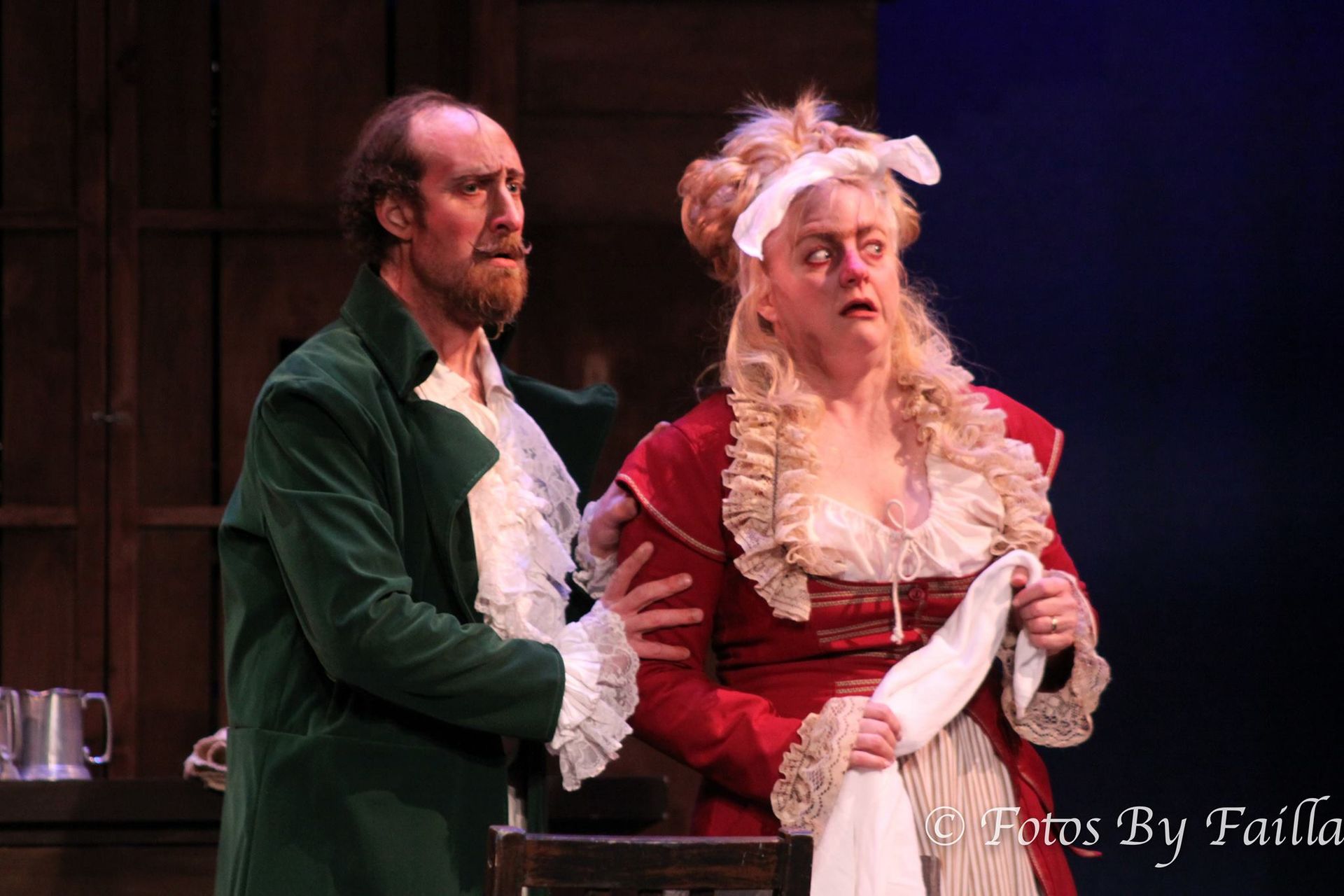 A man and a woman are standing next to each other on a stage.