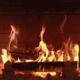 Fire burning in a brick fireplace with flames of yellow and orange.