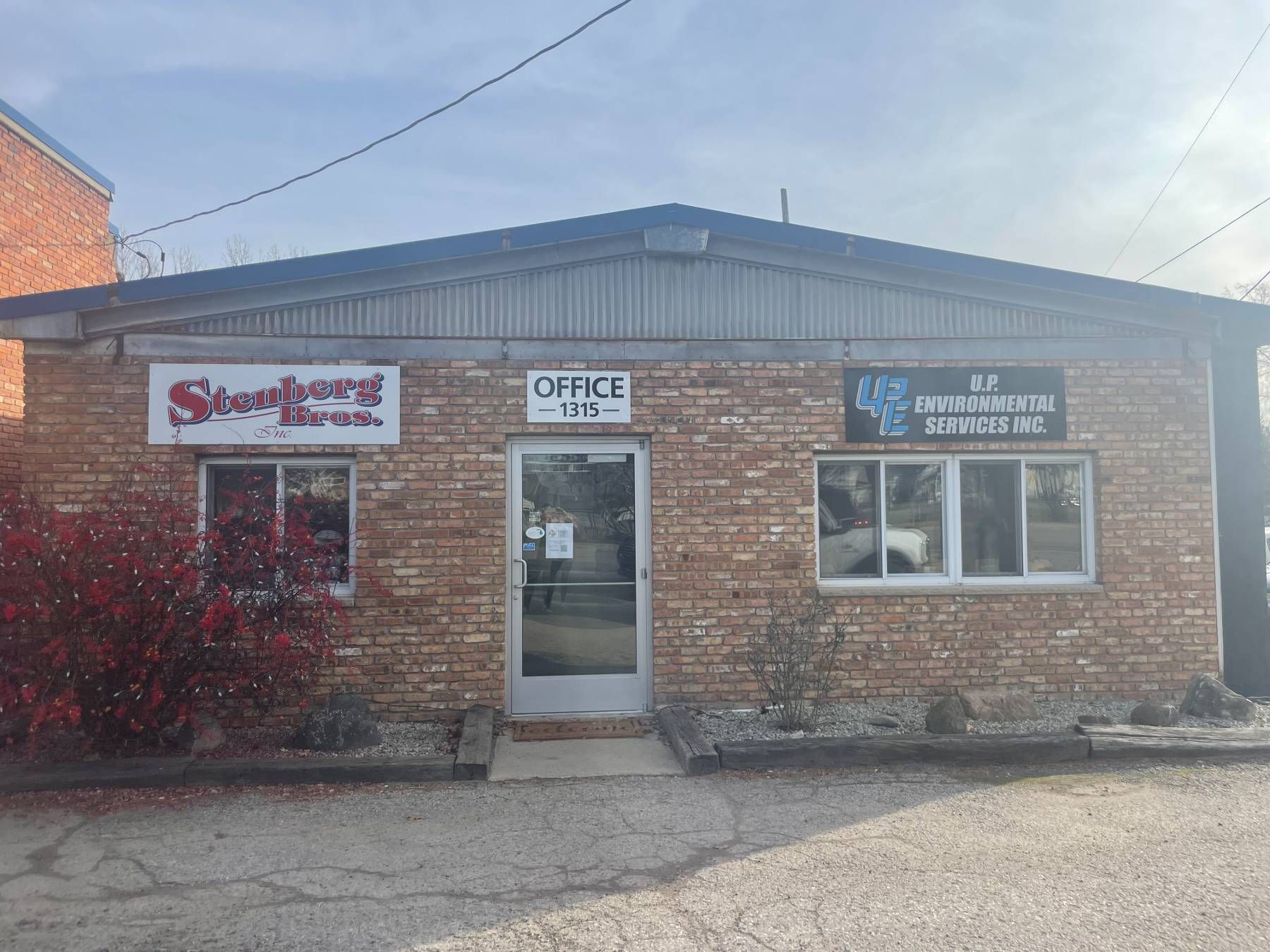 A brick building with a sign that says office on it