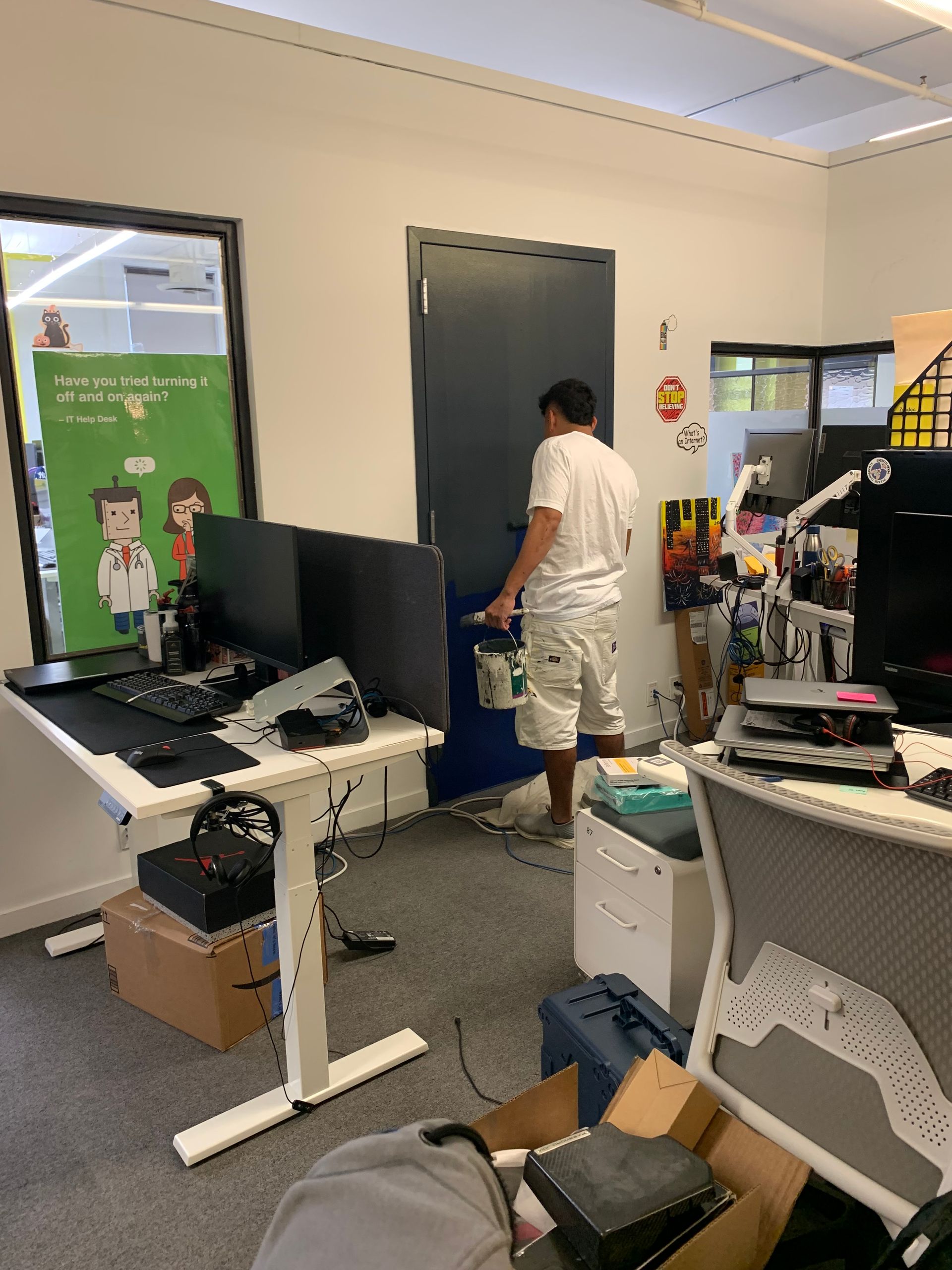 A man is painting a door in an office