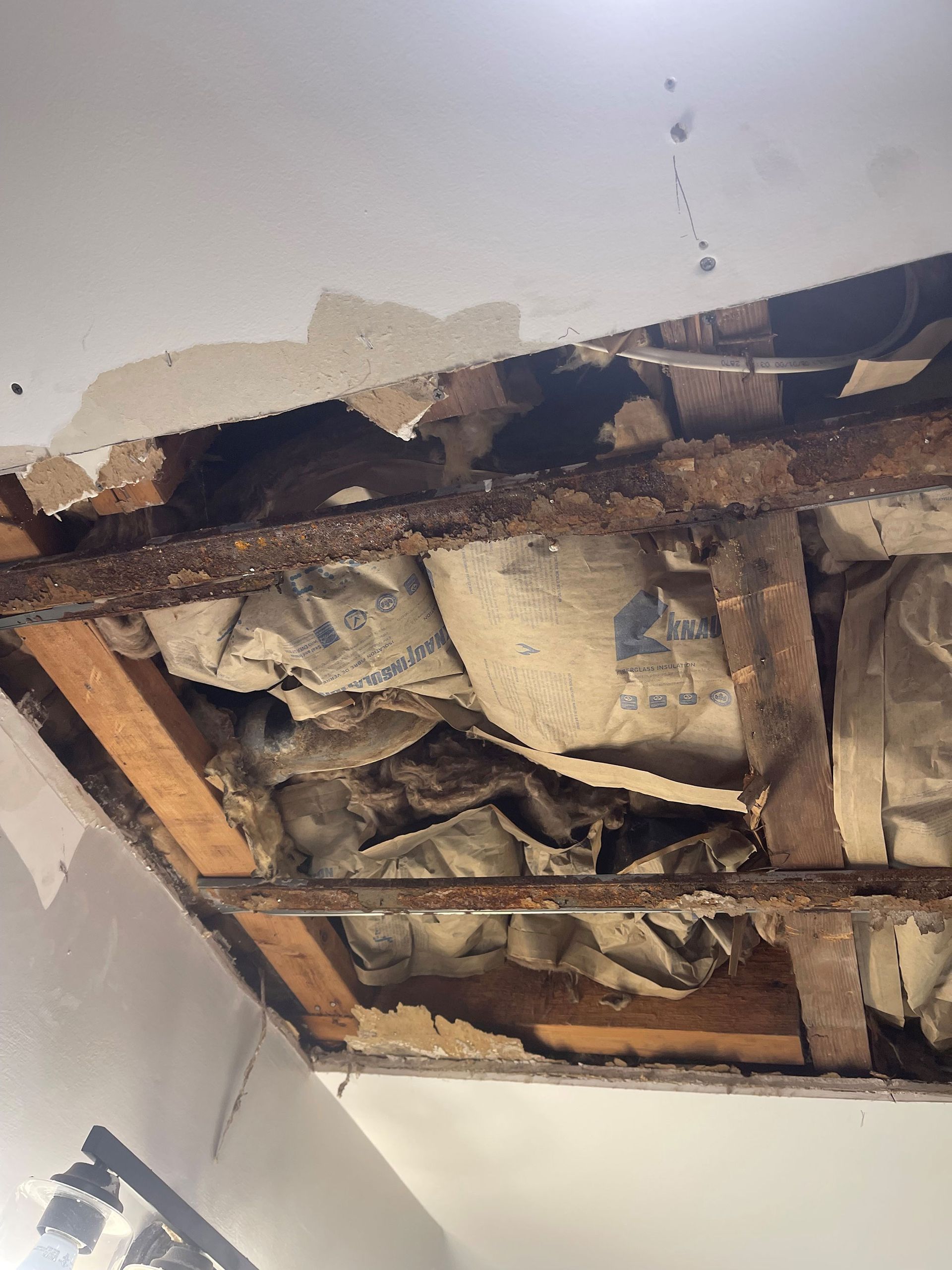 A ceiling with a hole in it and a lot of insulation.