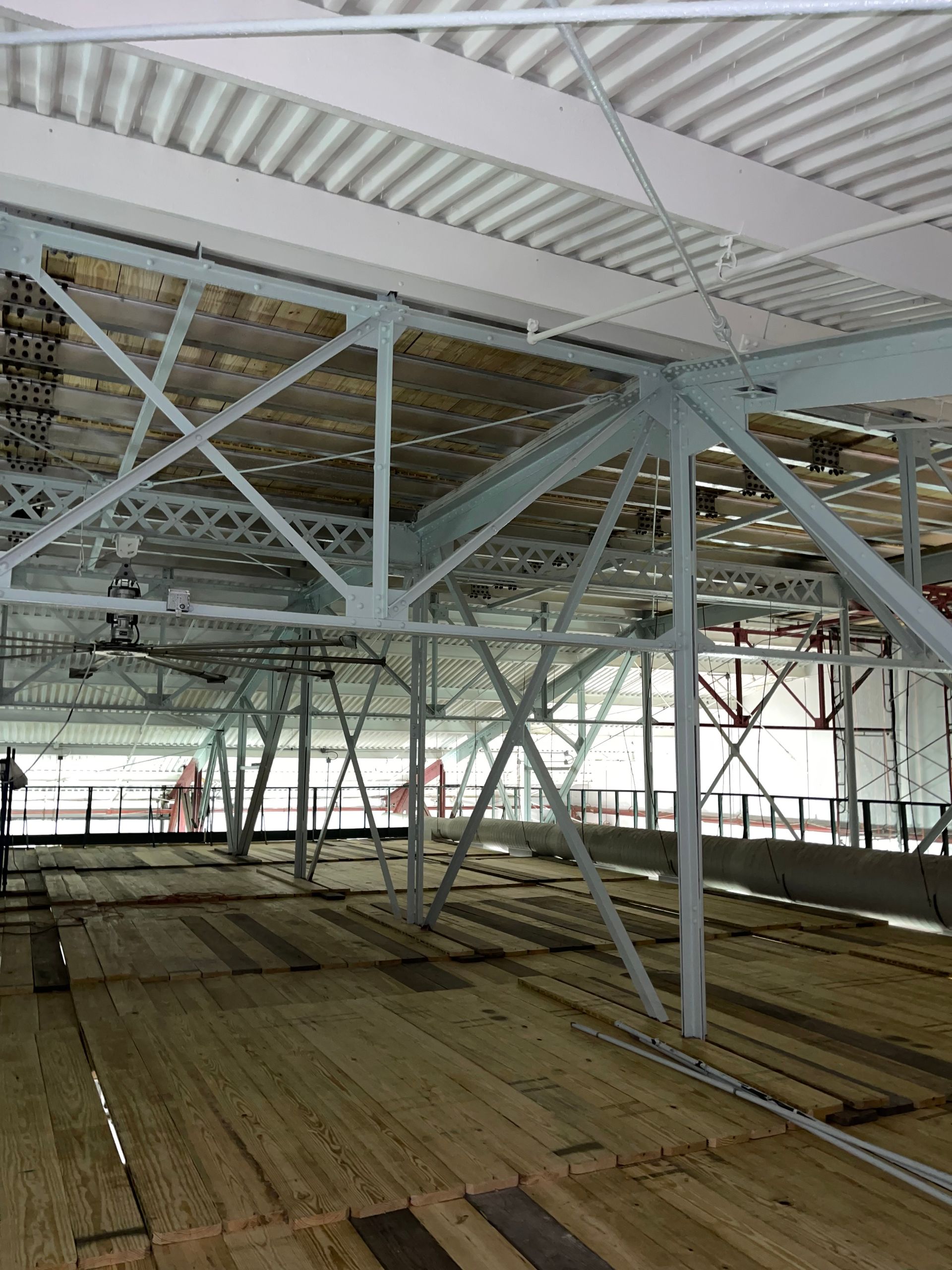 A large building with a lot of metal beams and a wooden floor