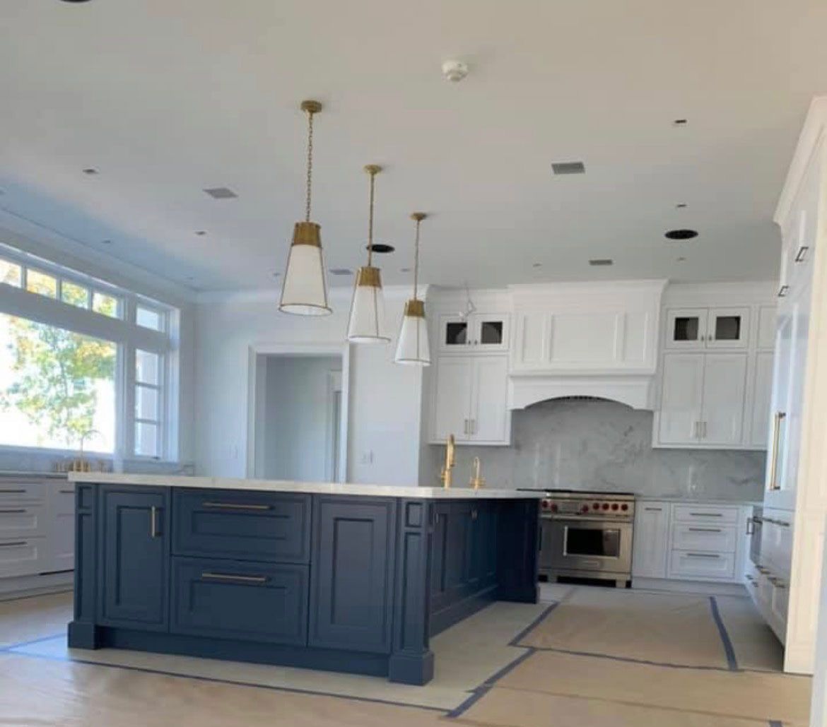 A kitchen with a large island and white cabinets
