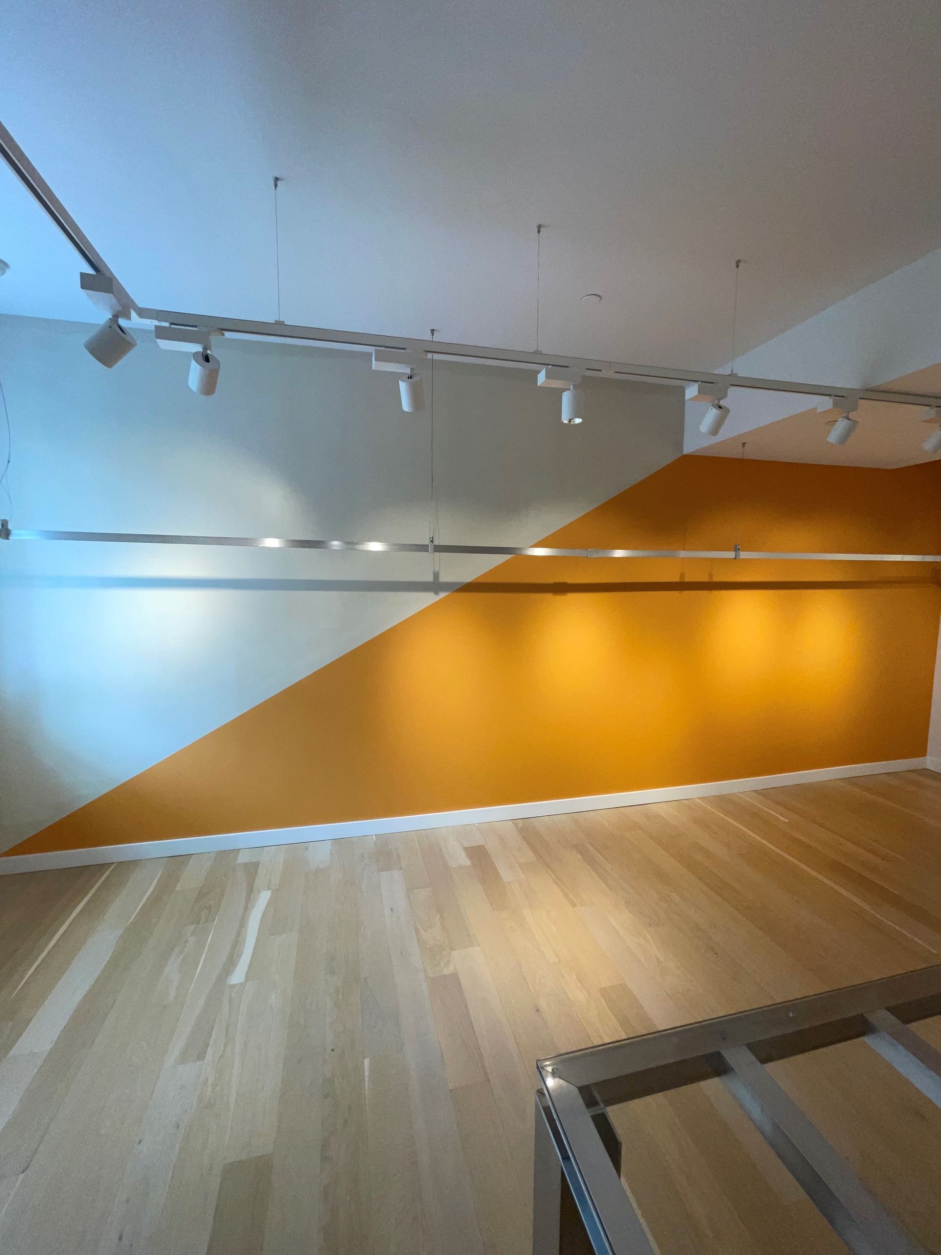 An empty room with orange and white walls and wooden floors