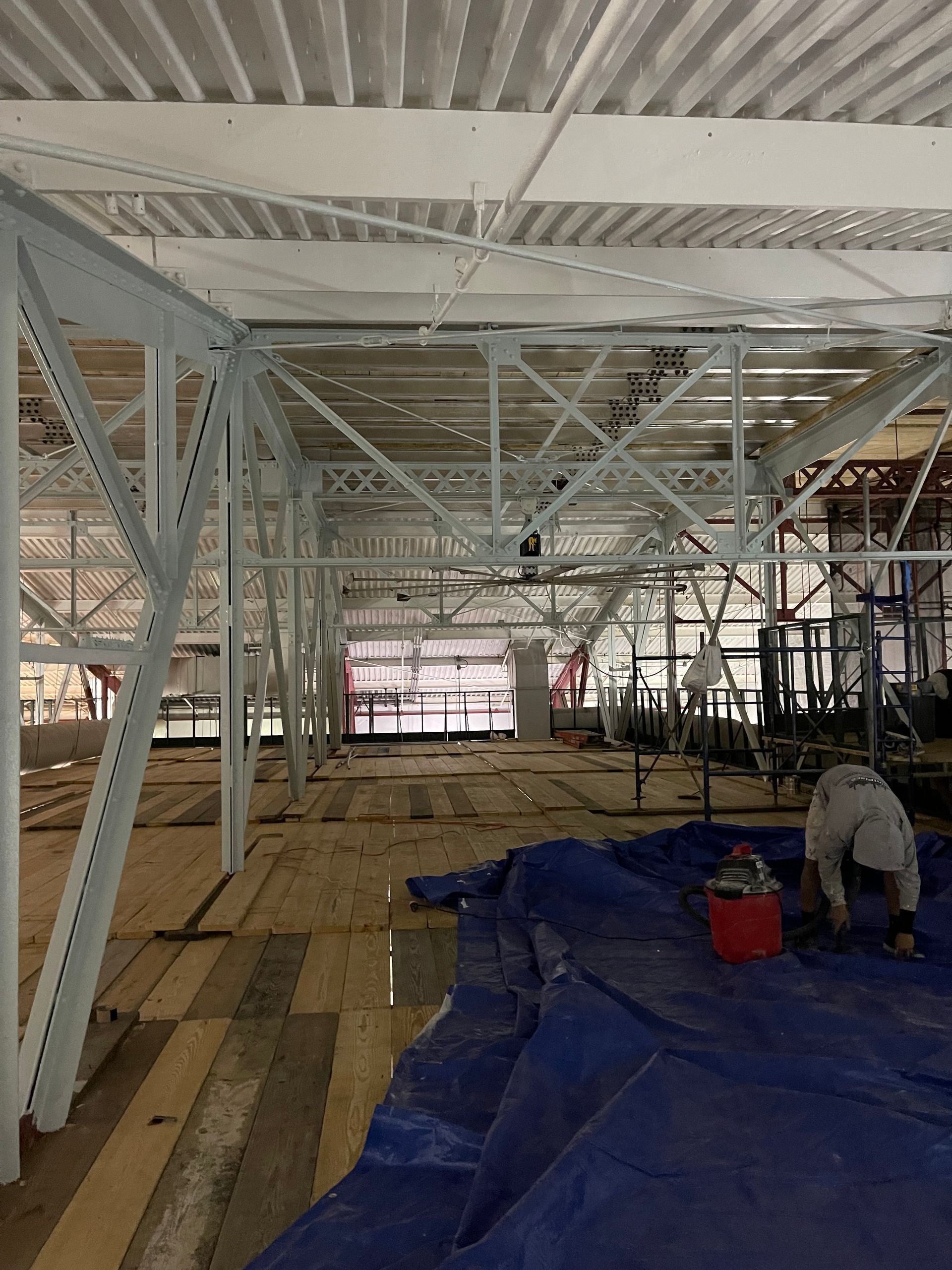 A large building under construction with a blue tarp on the floor