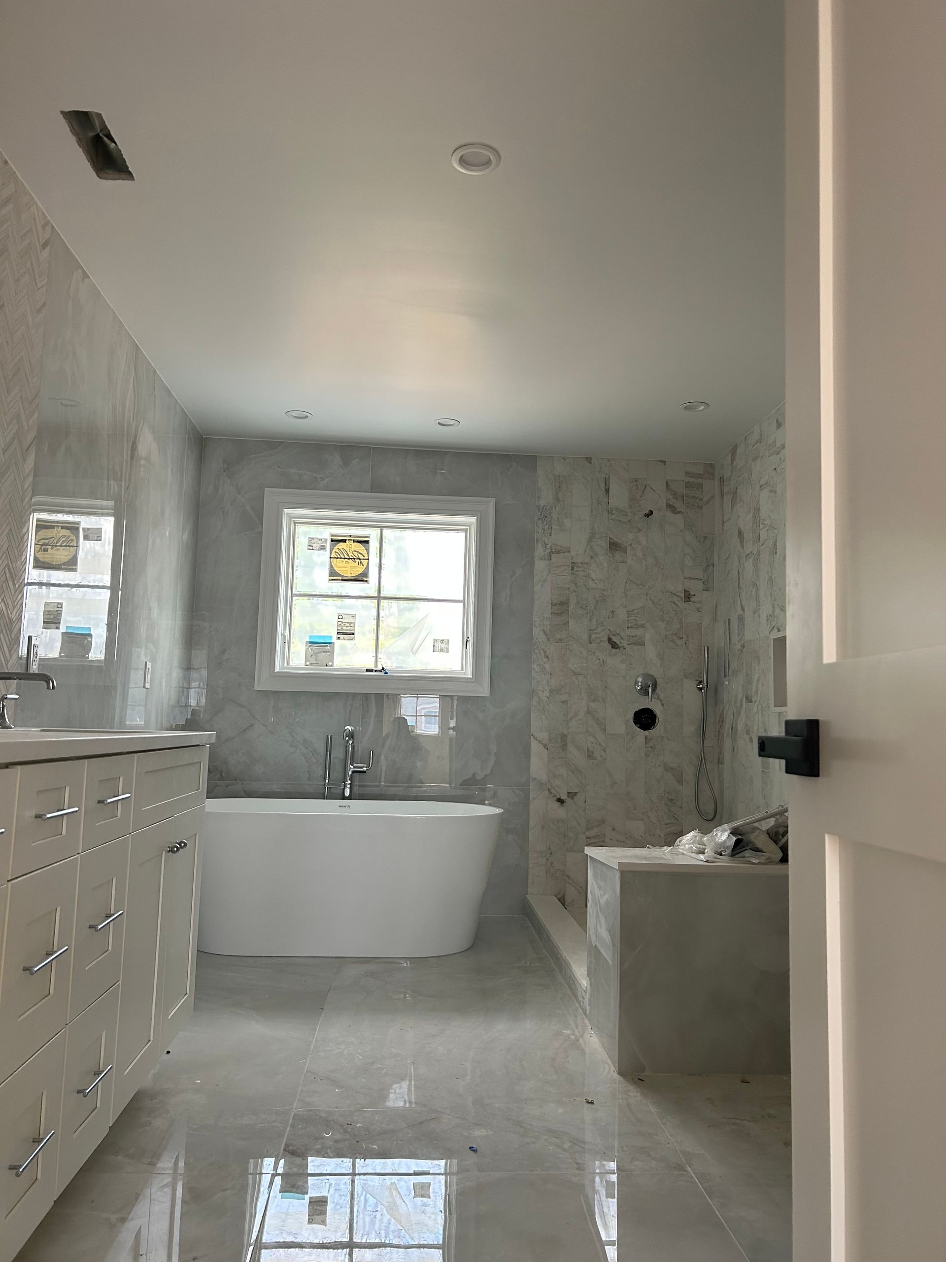 A bathroom with a tub, sink, and shower