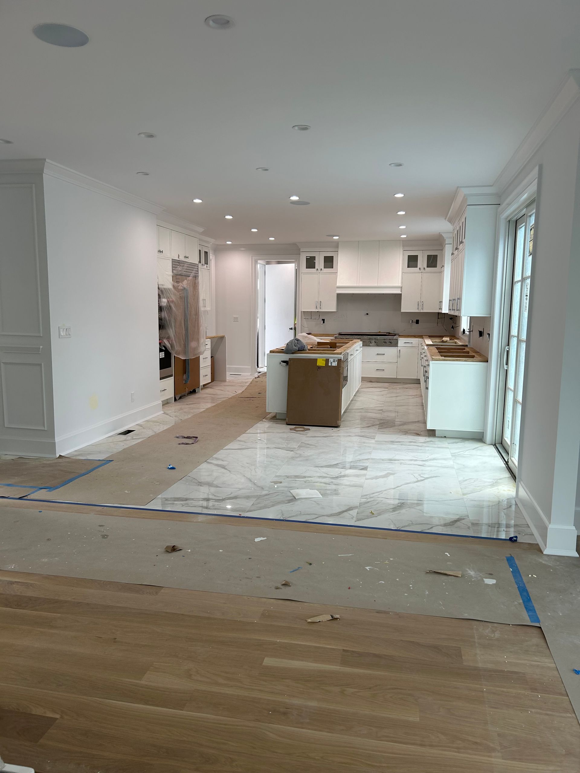 A kitchen with white cabinets and hardwood floors