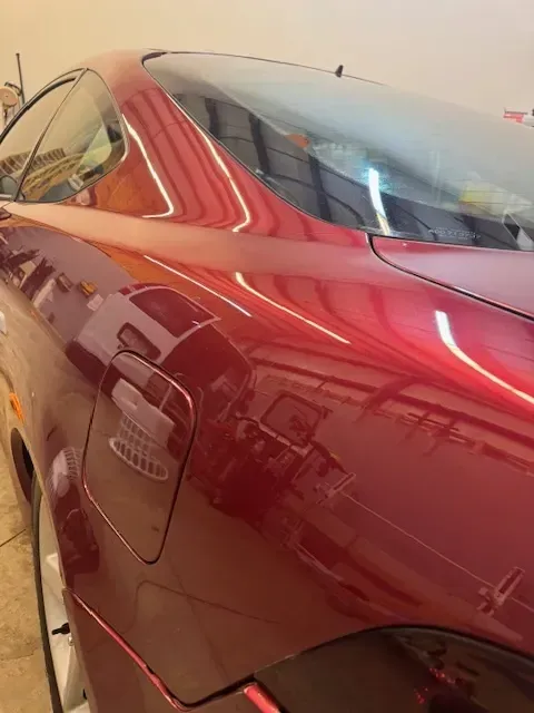Red coupe car, rear view, showing glossy paint.  Gas door and window visible.
