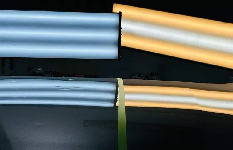Two parallel blue tubes, one angled yellow tube, with a thin green ribbon connecting them.