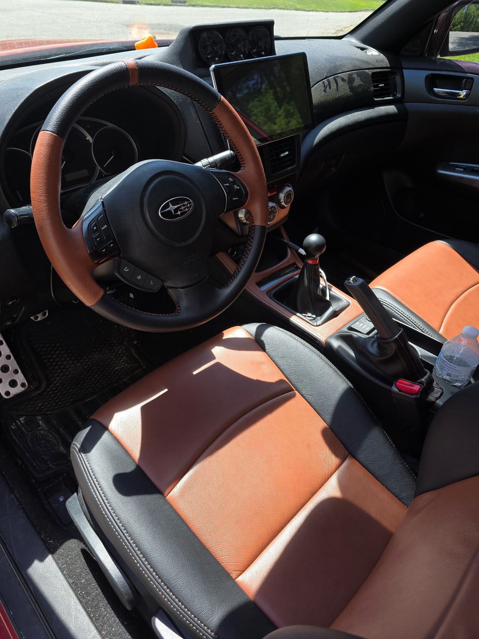 the interior of a car with brown and black seats and a steering wheel
