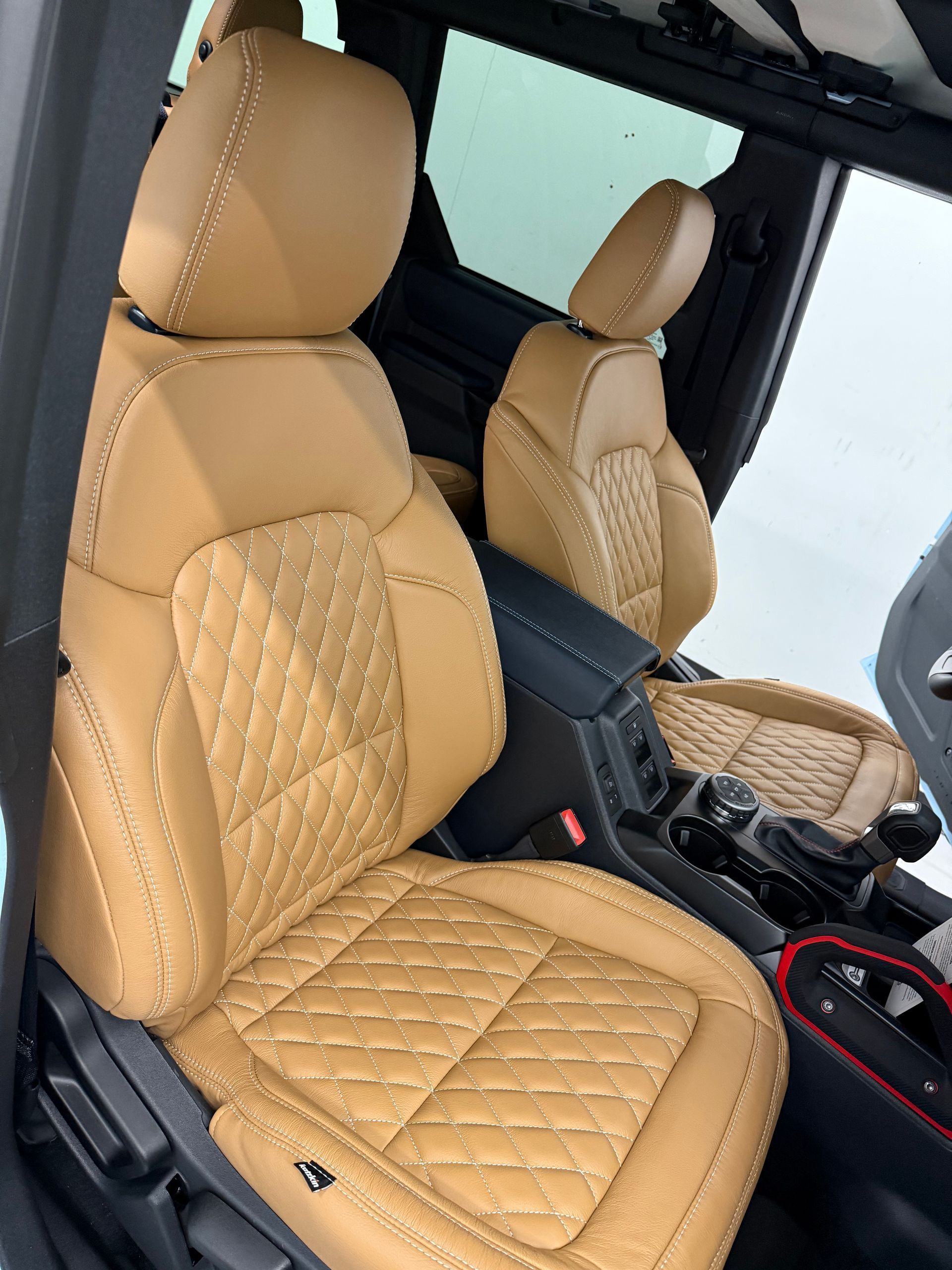 the front seats of a car are tan and quilted